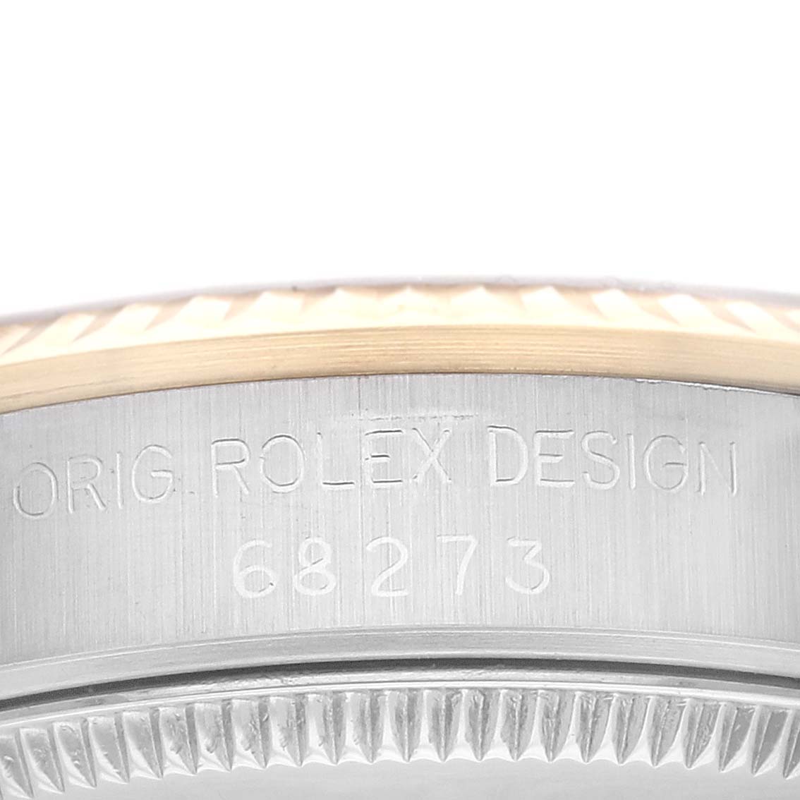 A close-up image of the side of a Rolex Mid-Size 68273 Women's Steel and Gold (two tone) Champagne Dial 68273 Women's Steel and Gold (two tone) Champagne Dial model watch, showing the engraving "ORIG. ROLEX DESIGN 68273".