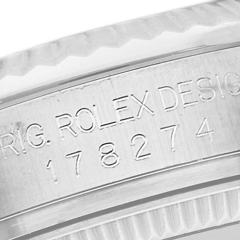 This is a close-up shot of the side of a Mid-Size Rolex watch, showing engraved details and part of the bezel.