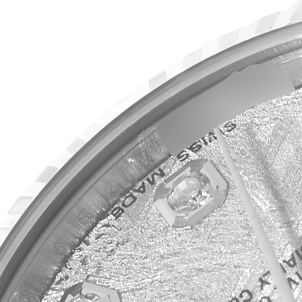 This close-up image of a Rolex Mid-Size 178274 Women
s Stainless Steel Silver Dial 178274 Women
s Stainless Steel Silver Dial watch shows the watch face with part of the bezel and a diamond marker.