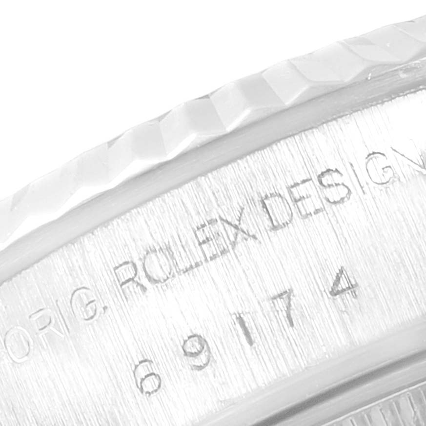 This close-up image shows the engraved serial number and fluted bezel of the Rolex Datejust 69174 Women
s Stainless Steel Silver Dial 69174 Women
s Stainless Steel Silver Dial watch.