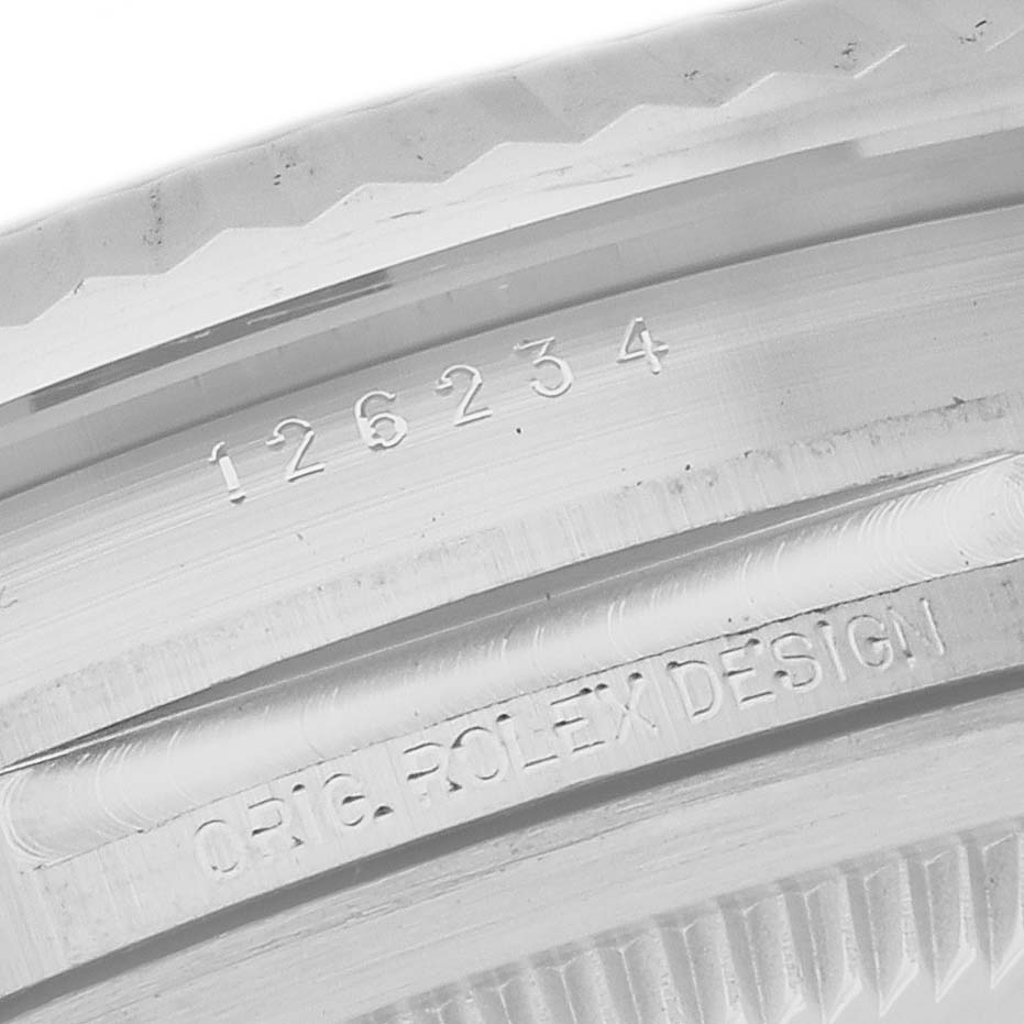 The image shows an angled close-up of the Rolex Datejust 126234 Men's Stainless Steel Silver Dial 126234 Men's Stainless Steel Silver Dial watch bezel, focusing on the model number and "ORIG. ROLEX DESIGN" engraving.