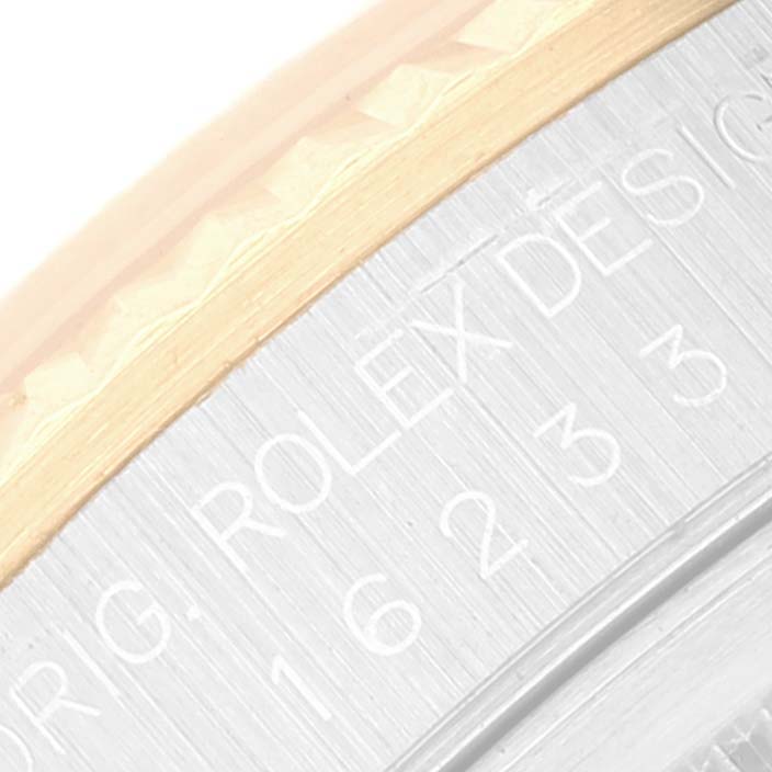 This close-up image shows the edge and some engraved text of the bezel and case of a Rolex Datejust 16233 Men's Steel and Gold (two tone) Champagne Dial 16233 Men's Steel and Gold (two tone) Champagne Dial watch.