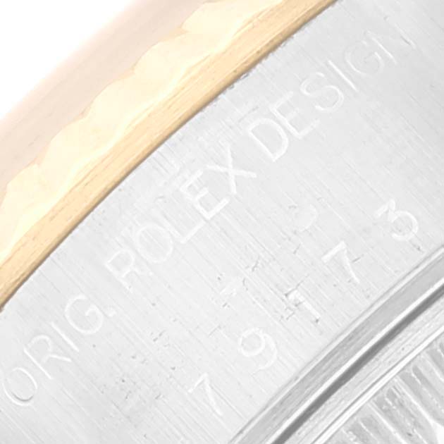 This image shows a close-up of the Rolex Datejust 79173 Women's Steel and Gold (two tone) Blue Dial 79173 Women's Steel and Gold (two tone) Blue Dial model's case side, displaying part of its bezel and engraved text.