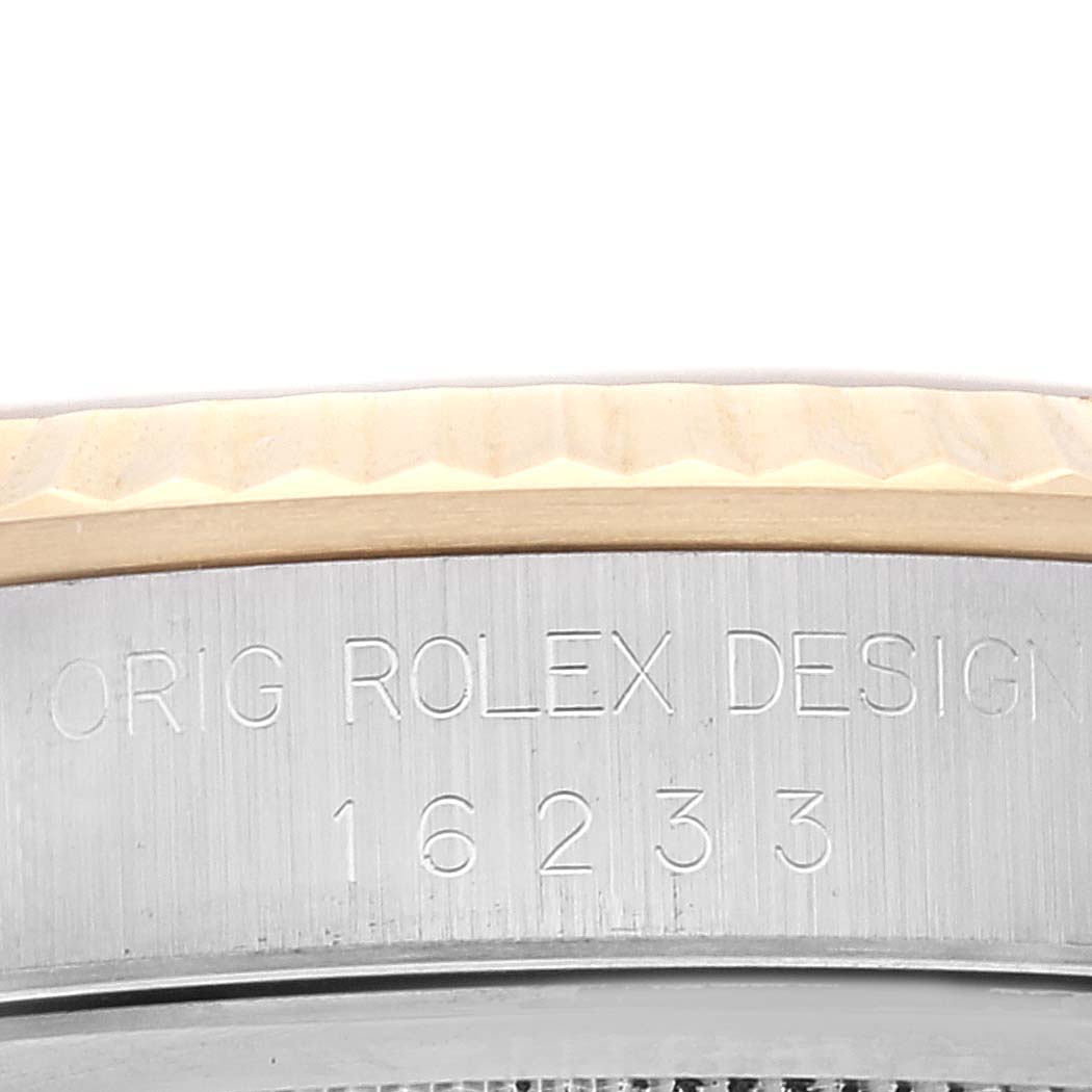 Close-up of the serial number and "ORIG ROLEX DESIGN" engraving on the side of a Rolex Datejust 16233 Men's Steel and Gold (two tone) Champagne Dial 16233 Men's Steel and Gold (two tone) Champagne Dial watch bezel.