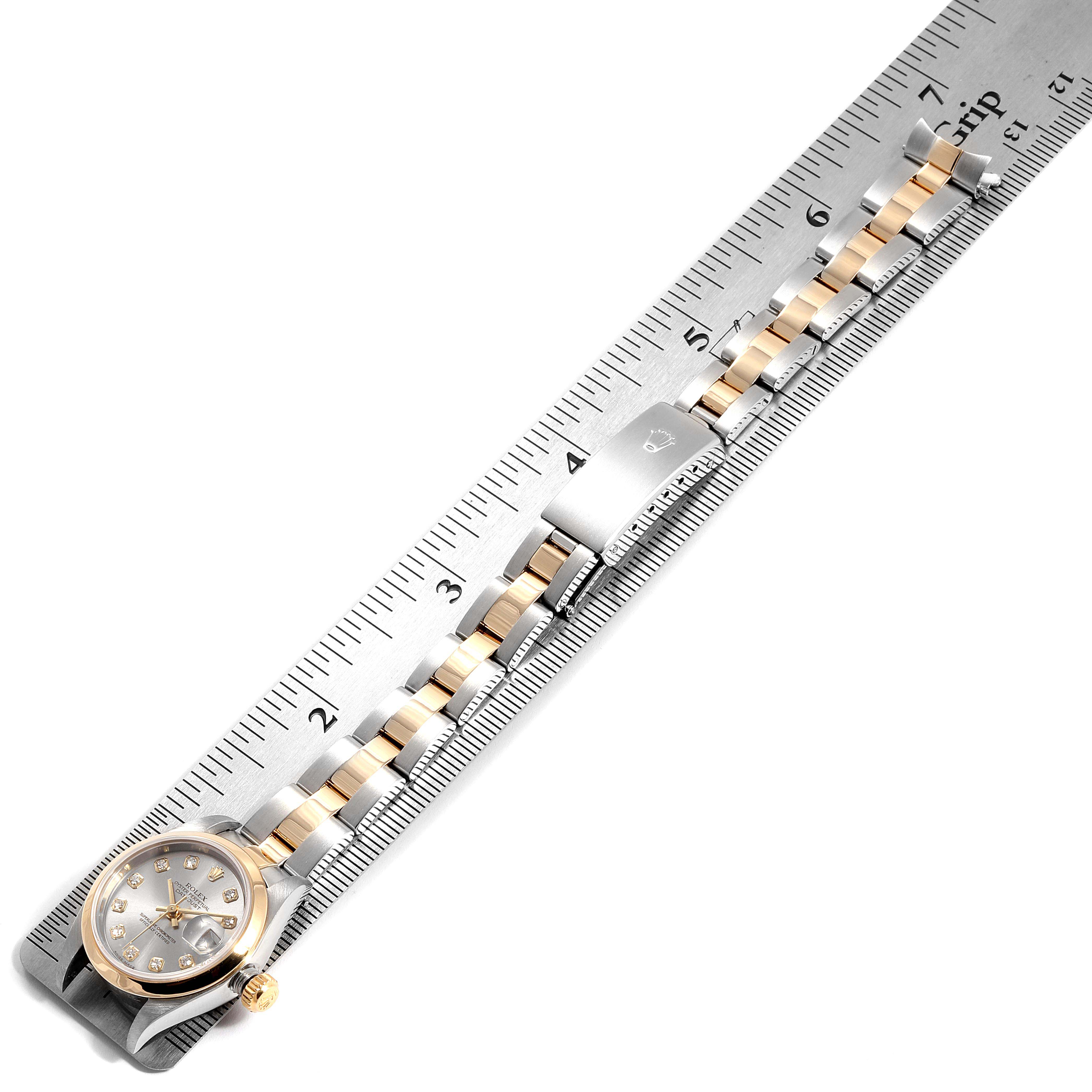 This image shows the Rolex Datejust 79163  Women
s Steel and Gold (two tone) Grey Dial 79163  Women
s Steel and Gold (two tone) Grey Dial watch positioned horizontally alongside a ruler, focusing on the face, bracelet, and clasp.