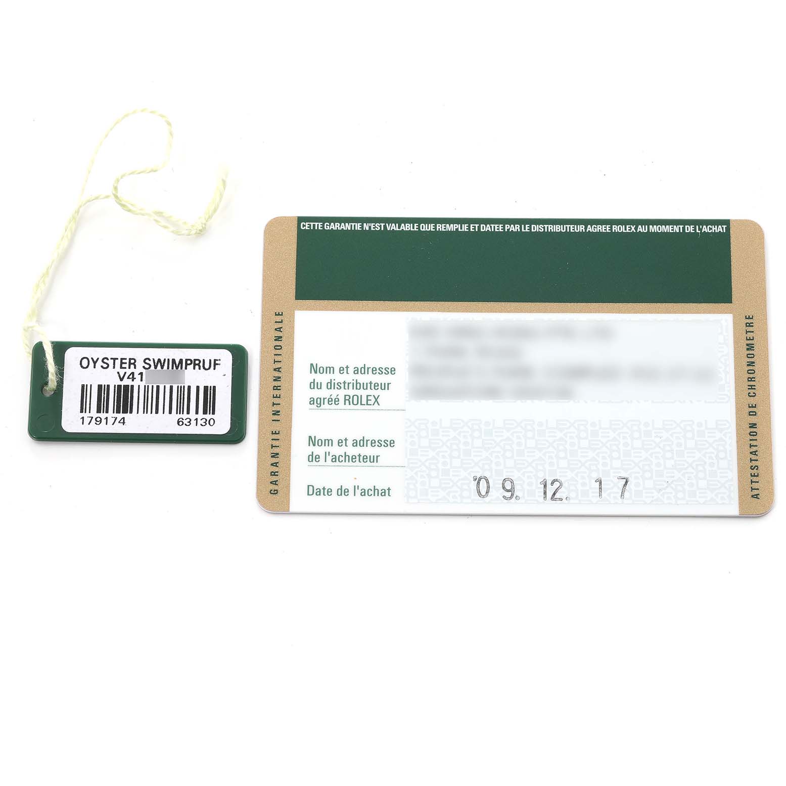The image shows a Rolex Datejust 179174 Women's Steel and Gold (two tone) Black Dial 179174 Women's Steel and Gold (two tone) Black Dial model's warranty card and an Oyster Swimpruf tag from a top-down angle.