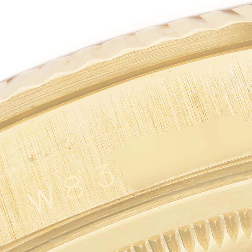 This close-up image of a Rolex President 18238 Men
s Yellow Gold Mother of Pearl Dial 18238 Men
s Yellow Gold Mother of Pearl Dial model watch shows the gold fluted bezel and part of the case with a serial number partially visible.