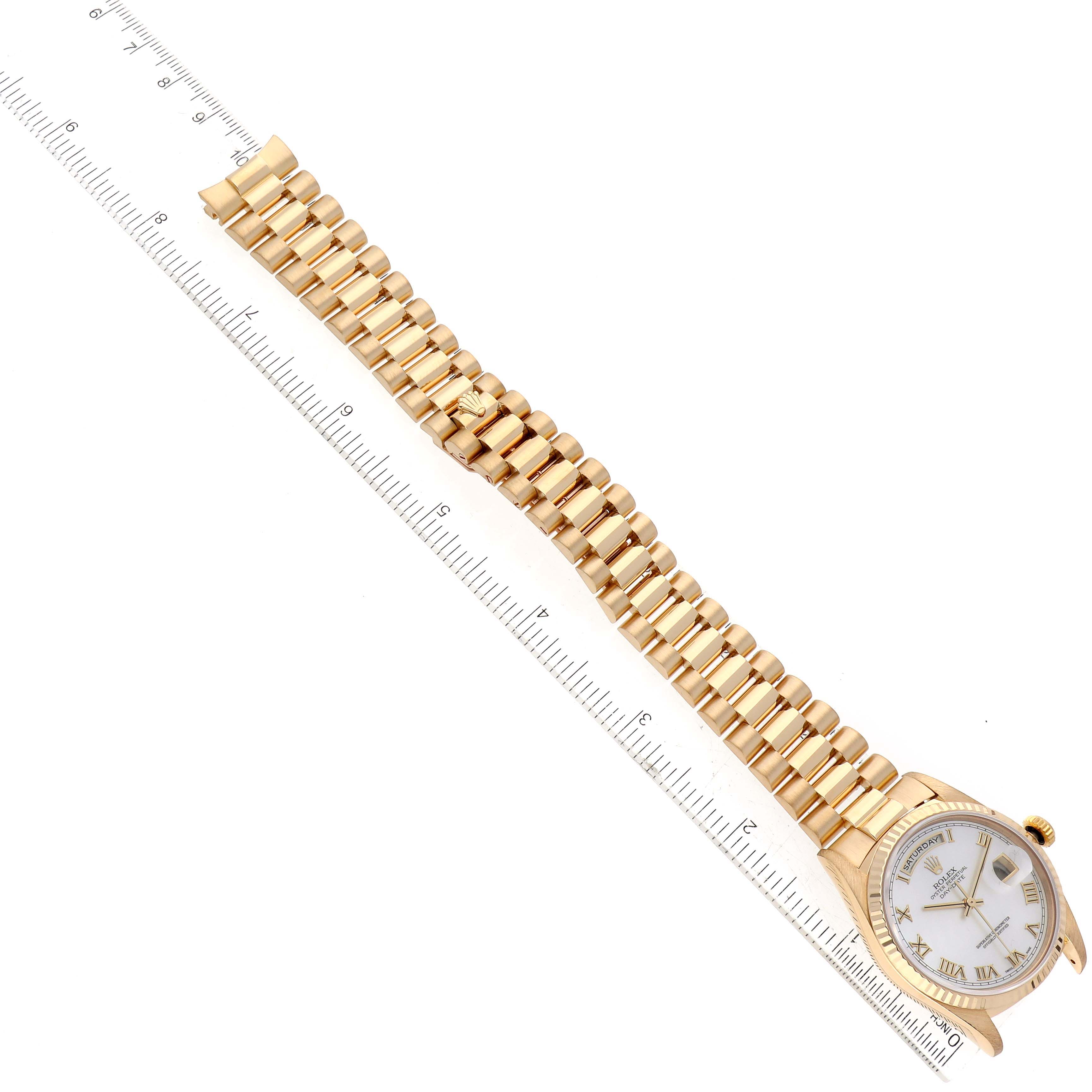 The image shows a Rolex President 18238 Men
s Yellow Gold Mother of Pearl Dial 18238 Men
s Yellow Gold Mother of Pearl Dial model watch laid flat with its gold bracelet and dial fully visible, alongside a measuring ruler.