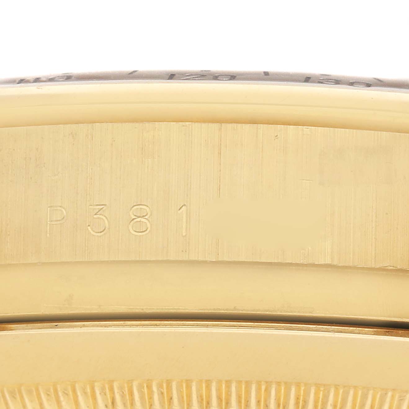 The image shows a close-up of the side of a Rolex Daytona 116528 Men
s Yellow Gold Black Dial 116528 Men
s Yellow Gold Black Dial, focusing on the engraved serial number on the case.