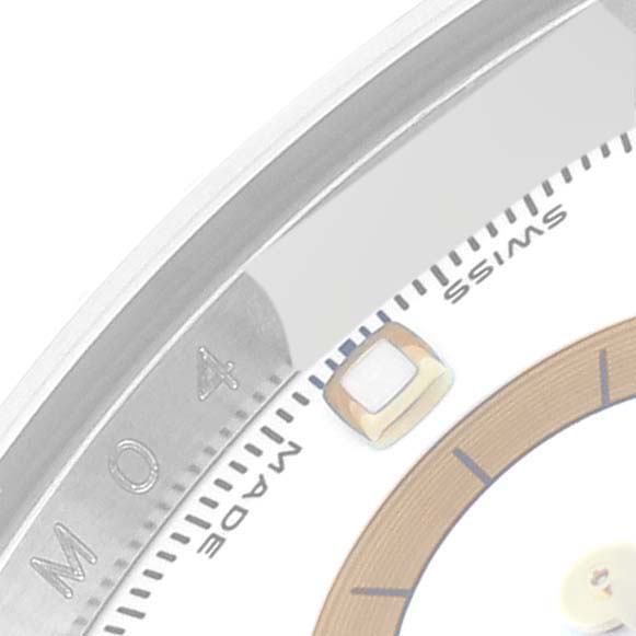 The image shows a close-up of the dial and edge of a Rolex Daytona 116523 Men
s Steel and Gold (two tone) White Dial 116523 Men
s Steel and Gold (two tone) White Dial watch, featuring part of the numeral and hour marker.