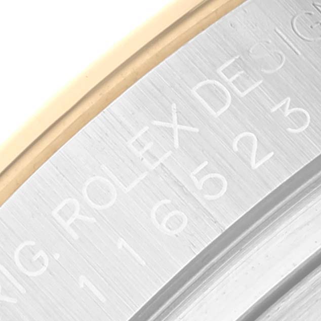 This image shows a close-up of the engraved case side of a Rolex Daytona 116523 Men
s Steel and Gold (two tone) White Dial 116523 Men
s Steel and Gold (two tone) White Dial watch.