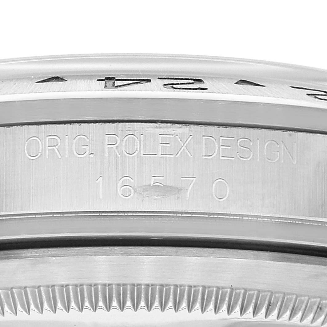 The image shows a close-up of the engraved side of a Rolex Explorer 16570 Men's Stainless Steel White Dial 16570 Men's Stainless Steel White Dial watch bezel, and model number 16570.