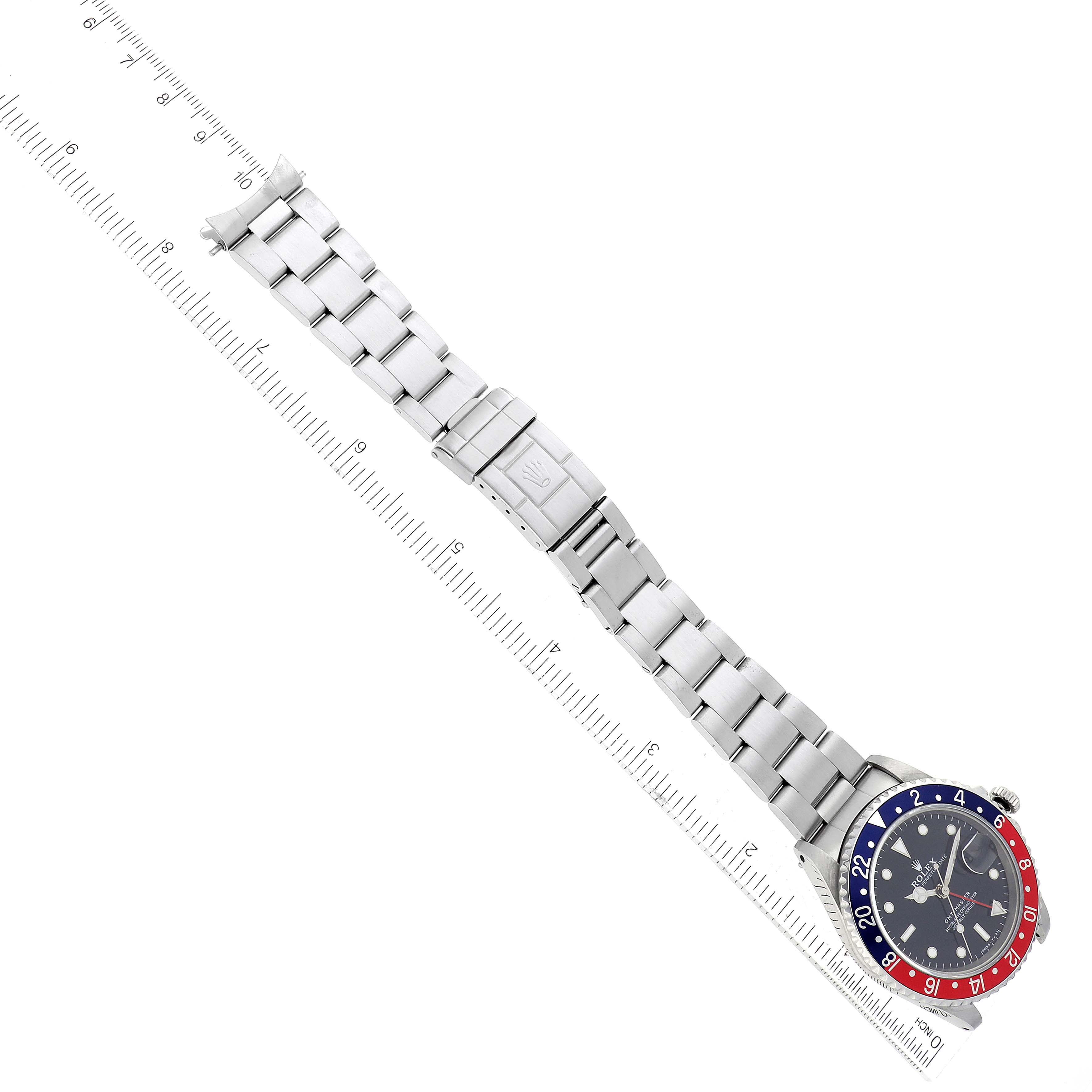 The image shows the Rolex GMT-Master 16700 Men's Stainless Steel Black Dial 16700 Men's Stainless Steel Black Dial watch laid flat with a metal bracelet, visible from top-down on a measurement ruler.