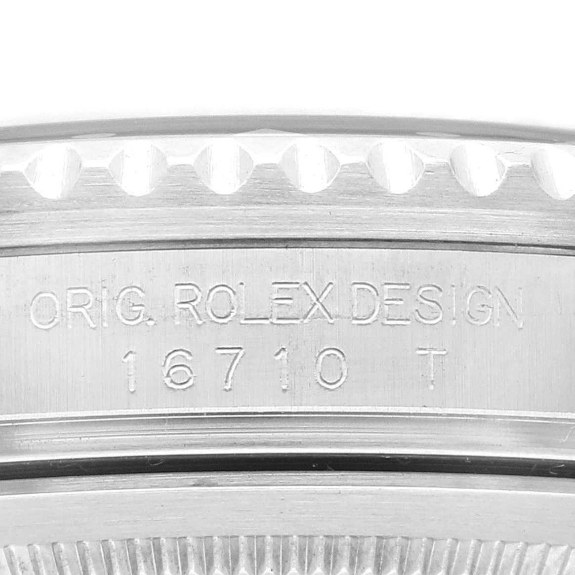 This image shows a close-up of the side of a Rolex GMT-Master 16710 Men's Stainless Steel Black Dial 16710 Men's Stainless Steel Black Dial watch, featuring the engraving with the model number "16710 T."
