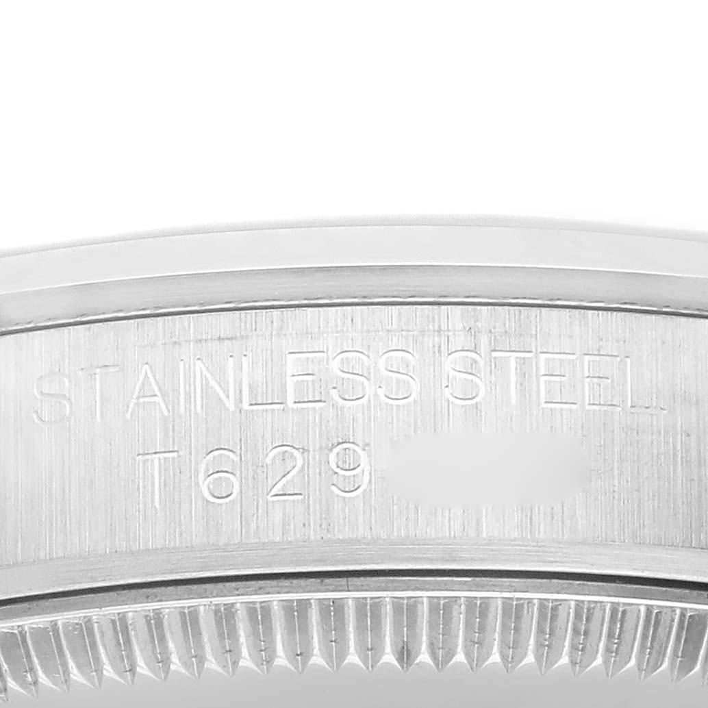 The image shows a close-up view of the caseback edge and engraving of a Mid-Size Rolex watch, featuring "STAINLESS STEEL" and a serial number.