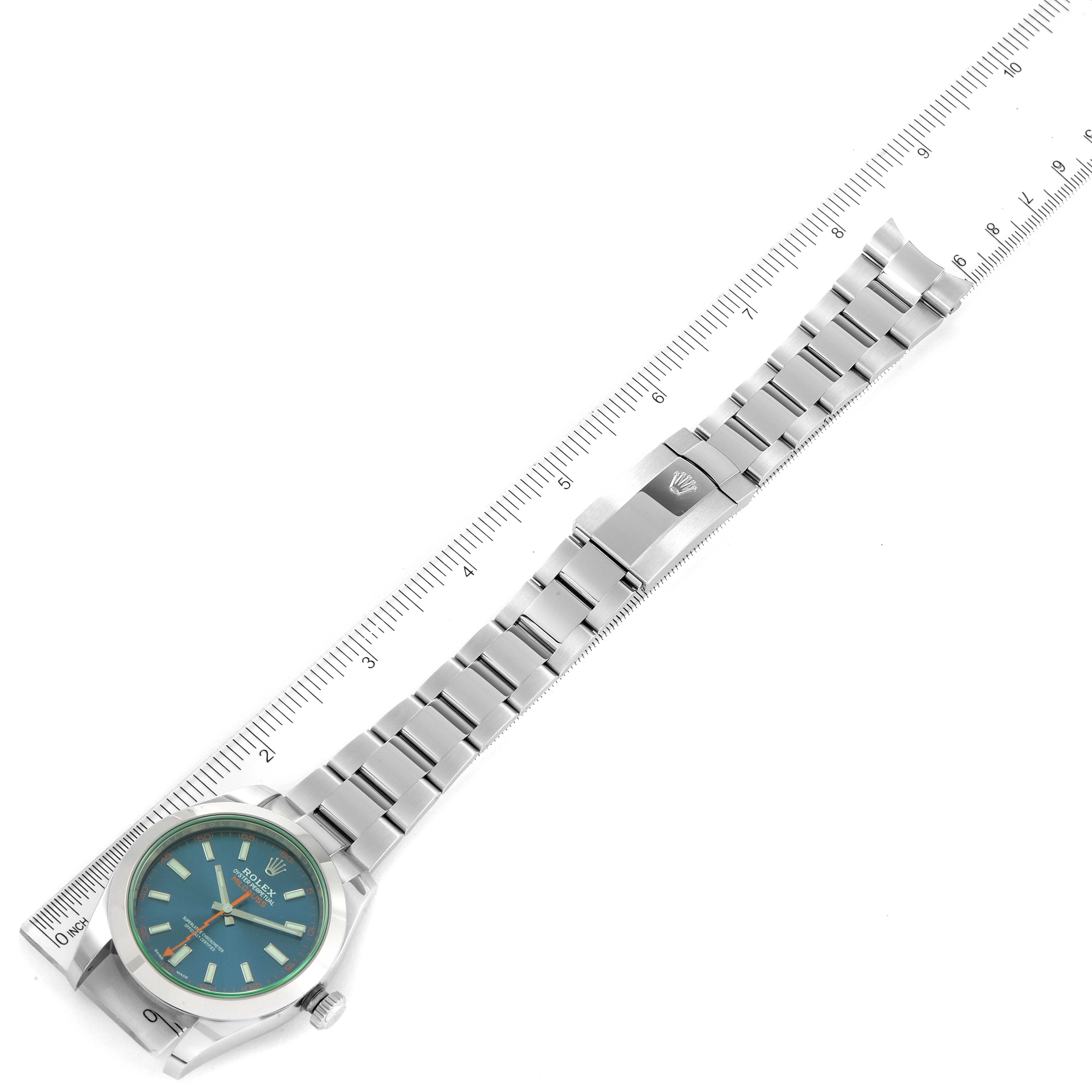 The image shows a Rolex Milgauss 116400GV Men
s Stainless Steel Blue Dial 116400GV Men
s Stainless Steel Blue Dial watch laid flat with its stainless steel bracelet aligned next to a ruler.