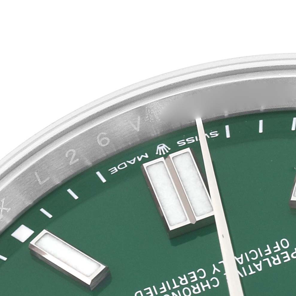 This image shows a close-up of the green dial and markers of a Rolex Oyster Perpetual 124300 Men's Stainless Steel Green Dial 124300 Men's Stainless Steel Green Dial watch at an oblique angle.