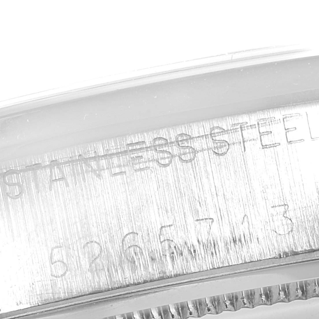 The image shows a close-up of the side of a Rolex Vintage Collection 6694 Men's Stainless Steel Champagne Dial 6694 Men's Stainless Steel Champagne Dial watch, highlighting the engraved text and stainless steel material.
