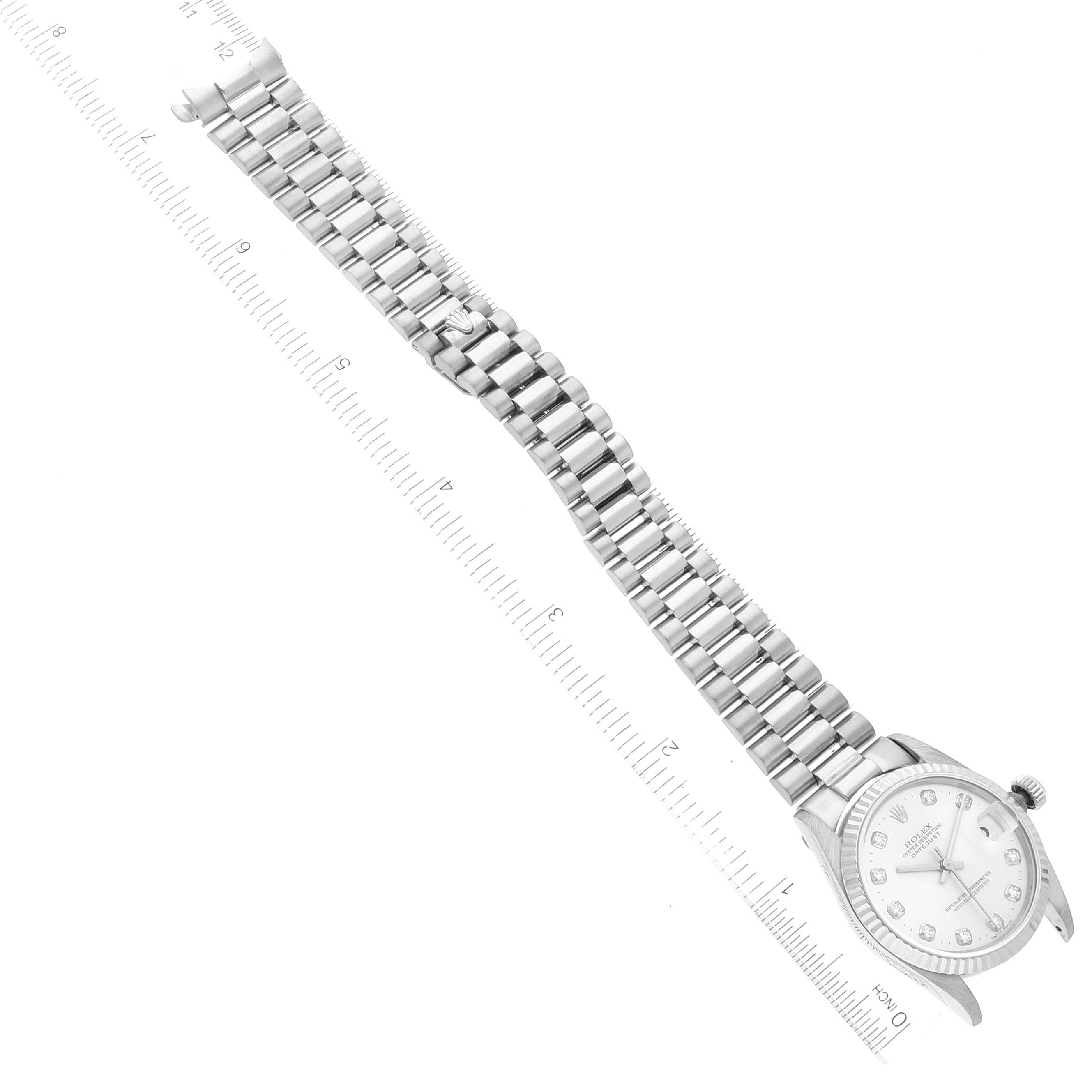 The image shows a Rolex President 68279 Women's White Gold Silver Dial 68279 Women's White Gold Silver Dial model watch lying flat with its full band and face visible, aligned next to a ruler.