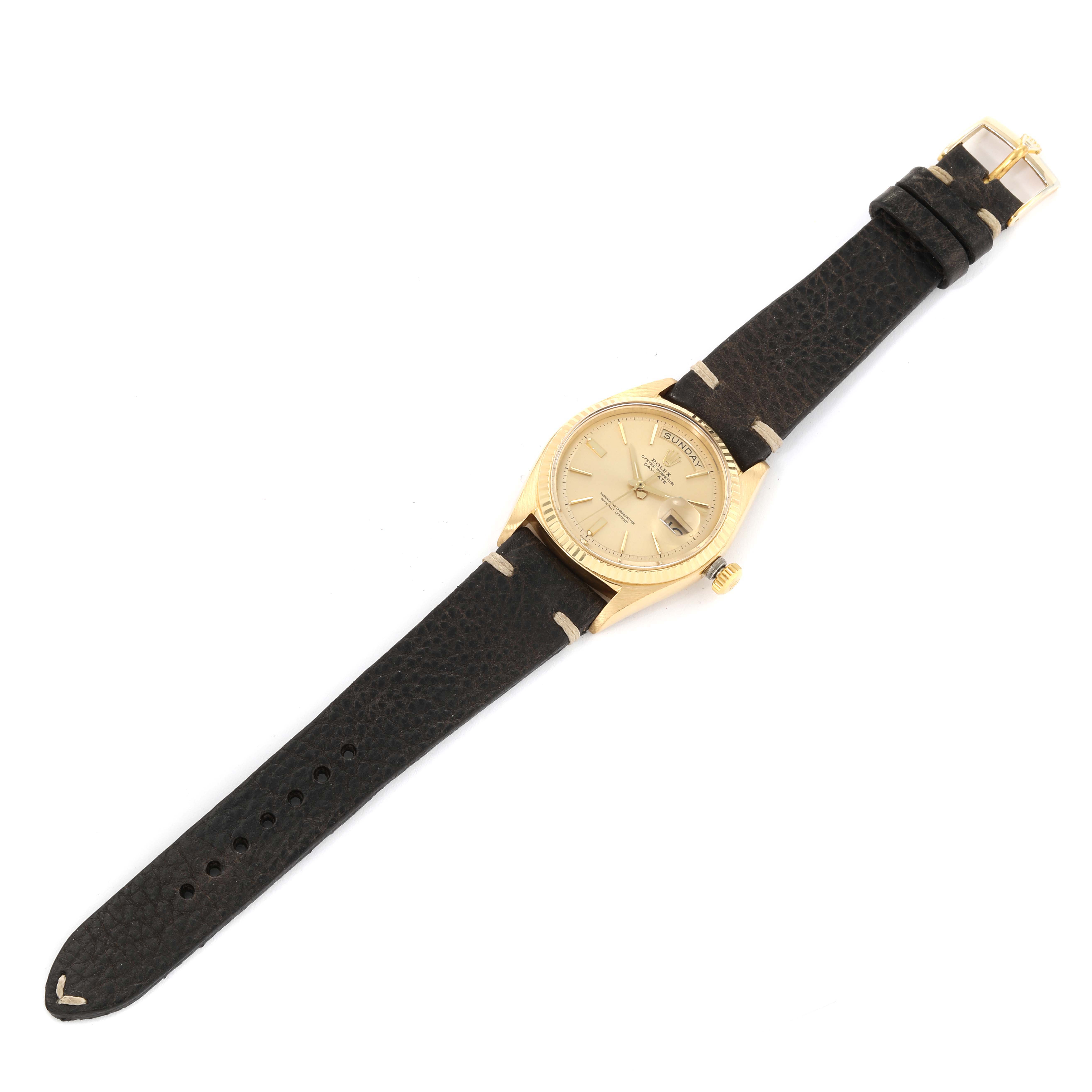 The image shows an aerial view of a Vintage Collection Rolex watch with a gold face and a black leather strap.