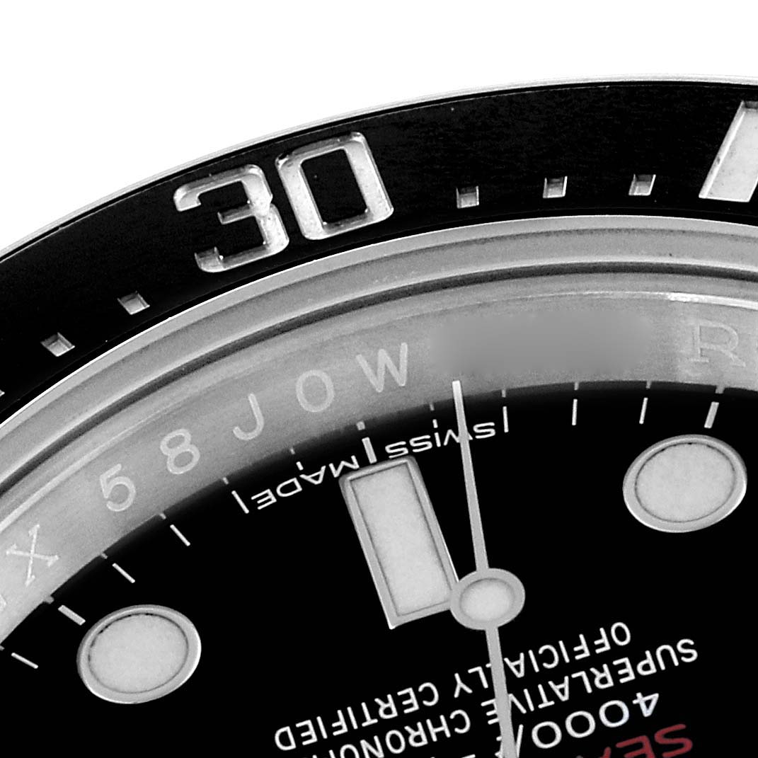 This close-up of the Rolex Sea-Dweller 126600 Men
s Stainless Steel Black Dial 126600 Men
s Stainless Steel Black Dial model shows part of the bezel with the "30" marker and a section of the dial with text and hour markers.