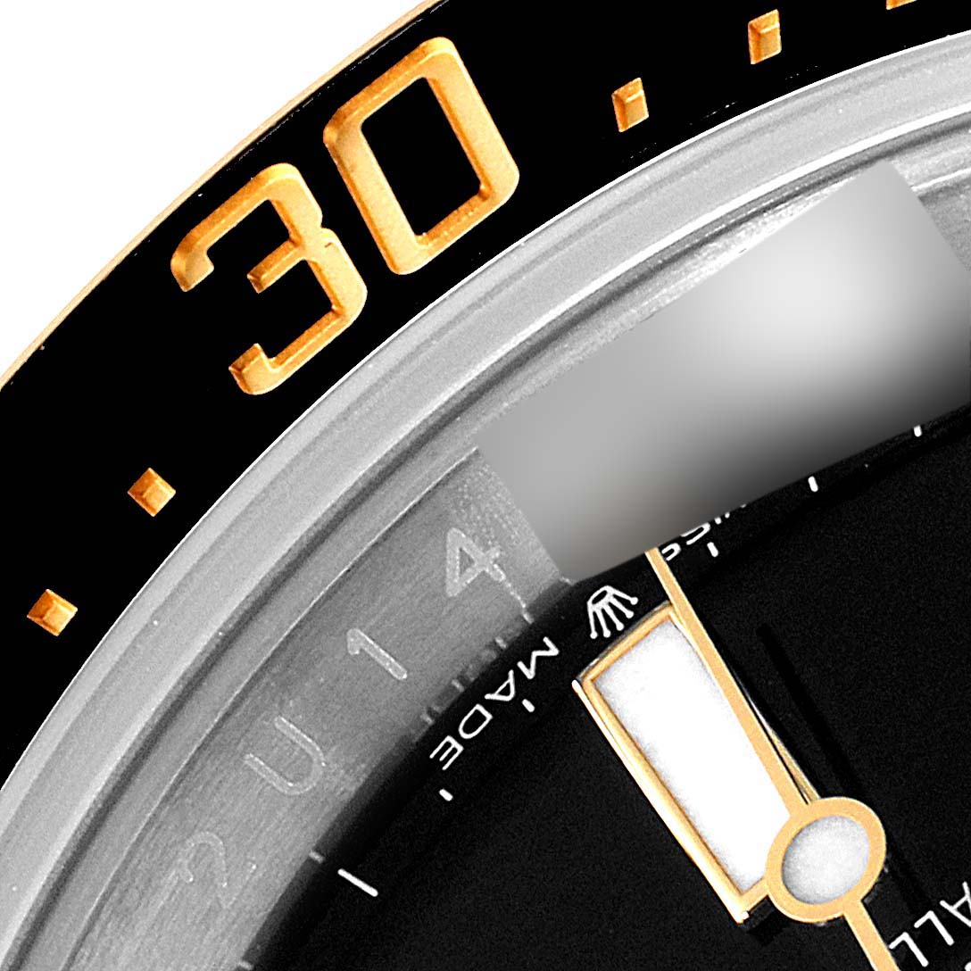 This close-up of the Rolex Sea-Dweller 126603 Men's Steel and Gold (two tone) Black Dial 126603 Men's Steel and Gold (two tone) Black Dial watch shows part of the bezel, minute hand, and dial.