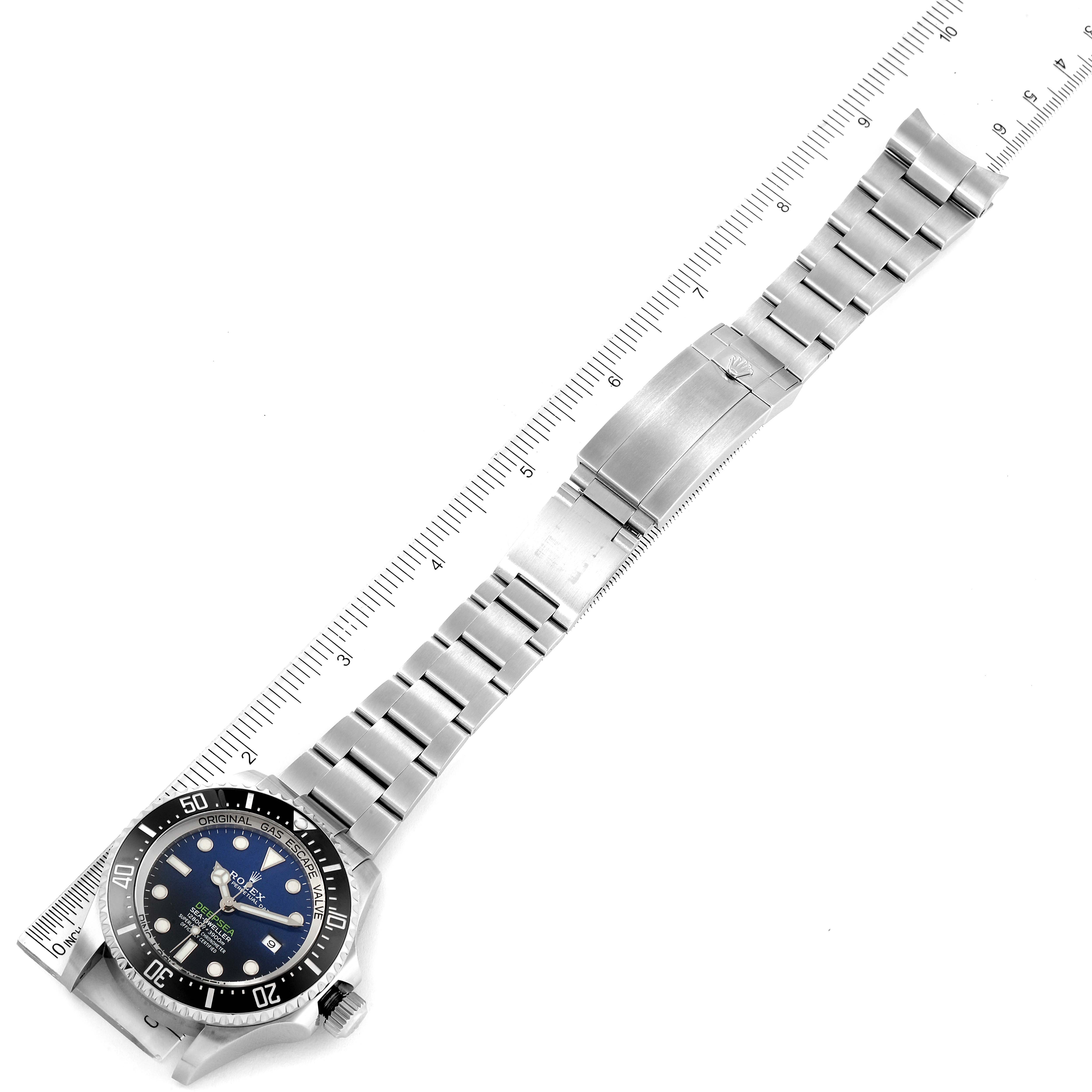 The Rolex Sea-Dweller 126660 Men
s Stainless Steel Blue Dial 126660 Men
s Stainless Steel Blue Dial watch is shown horizontally with the face, bezel, and bracelet fully extended alongside a ruler for scale.