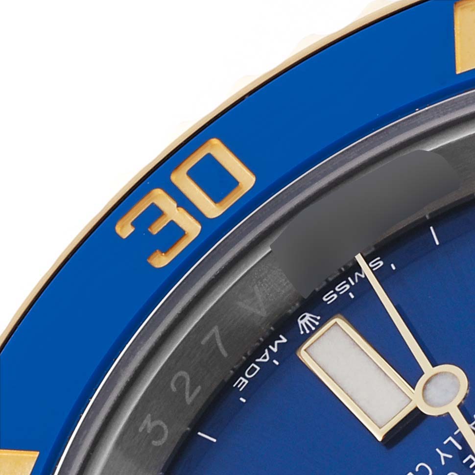 This image shows a close-up view of the bezel, dial, and part of the minute hand of a Rolex Submariner 126613 Men's Steel and Gold (two tone) Blue Dial 126613 Men's Steel and Gold (two tone) Blue Dial watch.