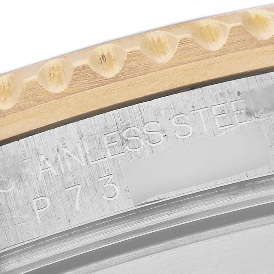 The image shows a close-up of the engraved bezel and metal case of a Rolex Submariner 16613 Men's Steel and Gold (two tone) Champagne Dial 16613 Men's Steel and Gold (two tone) Champagne Dial watch.