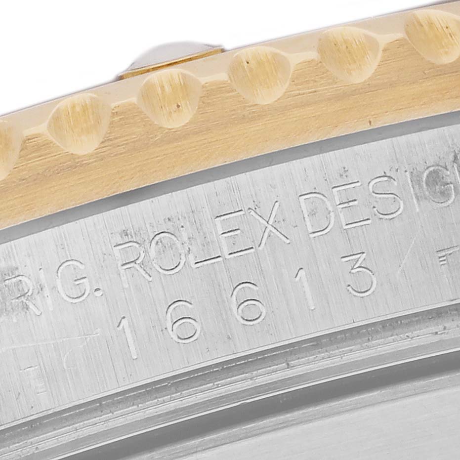 The image shows a close-up of the case and bezel edge of a Rolex Submariner 16613 Men's Steel and Gold (two tone) Champagne Dial 16613 Men's Steel and Gold (two tone) Champagne Dial watch, exposing the model number and brand engraving.
