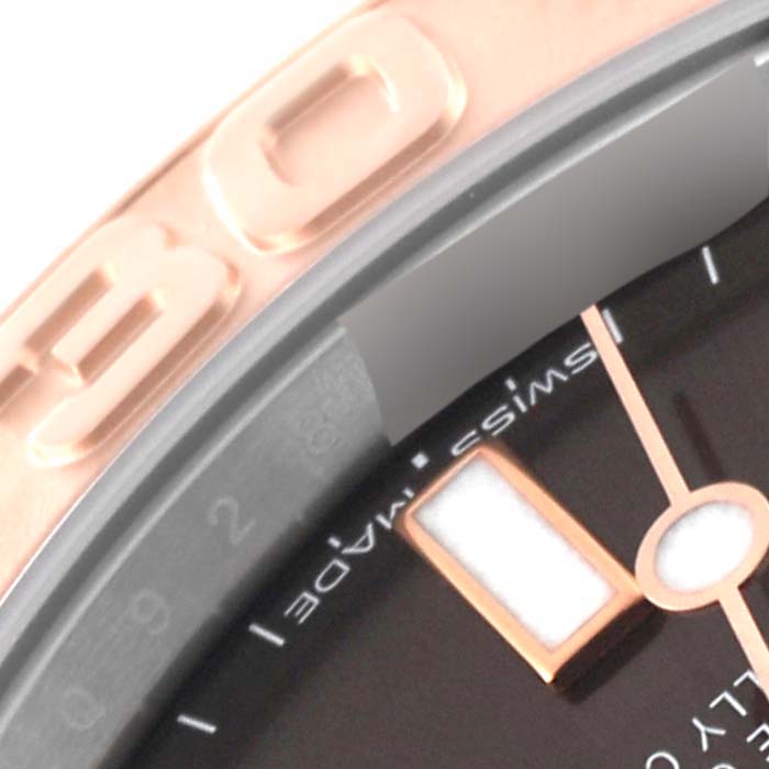 This close-up angle of the Rolex Yacht-Master 268621 Men's Steel and Gold (two tone) Brown Dial 268621 Men's Steel and Gold (two tone) Brown Dial watch shows part of the bezel, dial, and a marker.