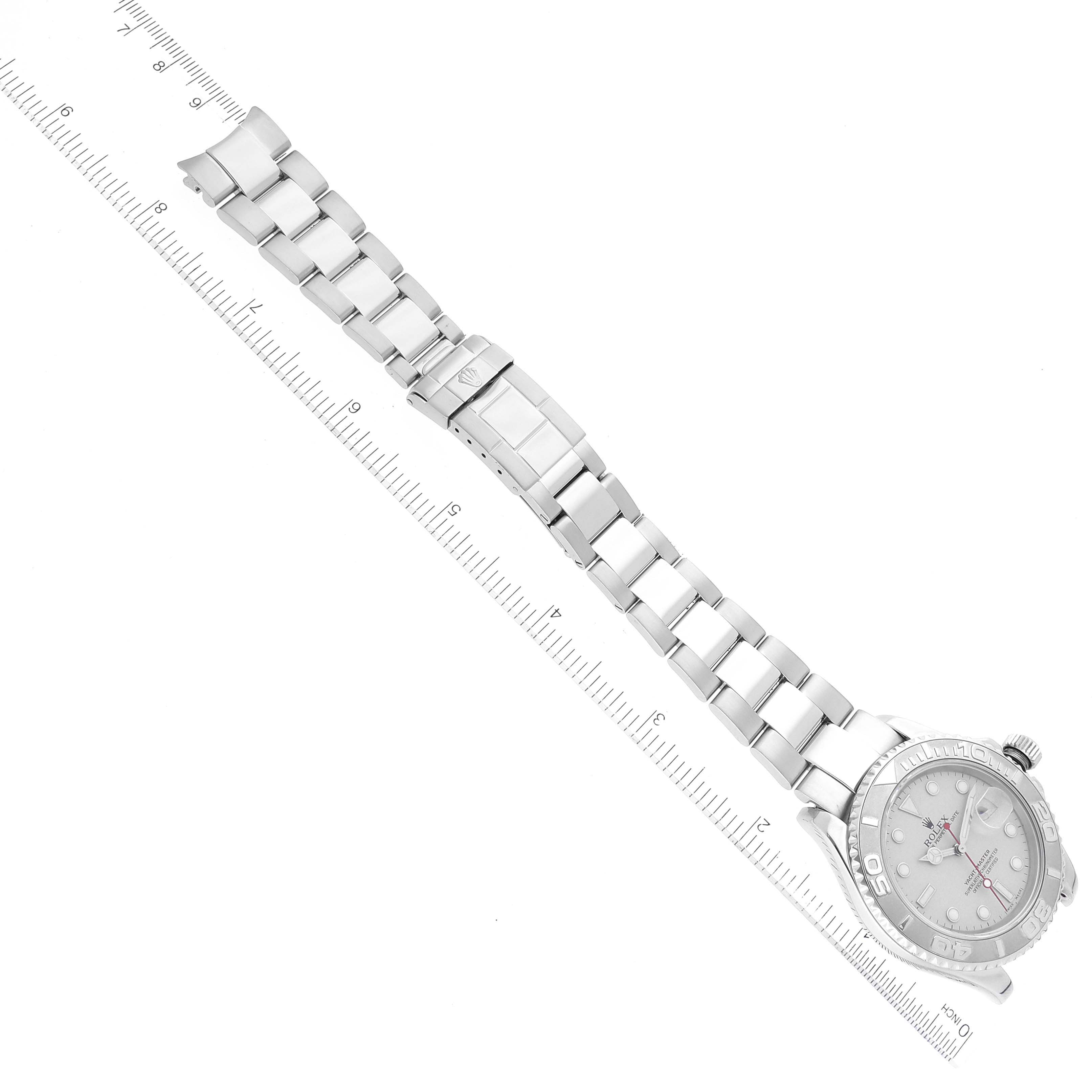 The image shows a top-down view of a Rolex Yacht-Master 16622 Men's Stainless Steel Silver Dial 16622 Men's Stainless Steel Silver Dial watch, highlighting its bracelet and partially the watch face with a ruler for scale.