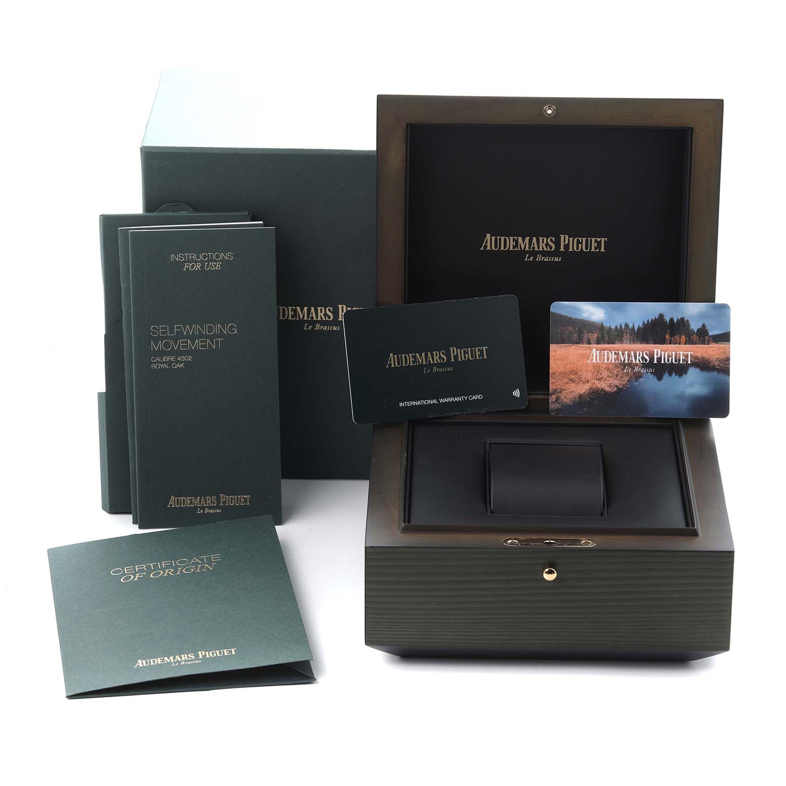 The image shows the packaging for an Audemars Piguet Royal Oak 15510ST.OO.1320ST.08 Men
s Stainless Steel Silver Dial 15510ST.OO.1320ST.08 Men
s Stainless Steel Silver Dial, including the box, manuals, and warranty cards, from a frontal angle.