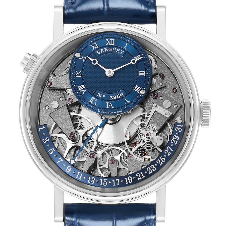 The Breguet Tradition watch is shown from the front, featuring its intricate dial, exposed mechanics, and a blue strap.