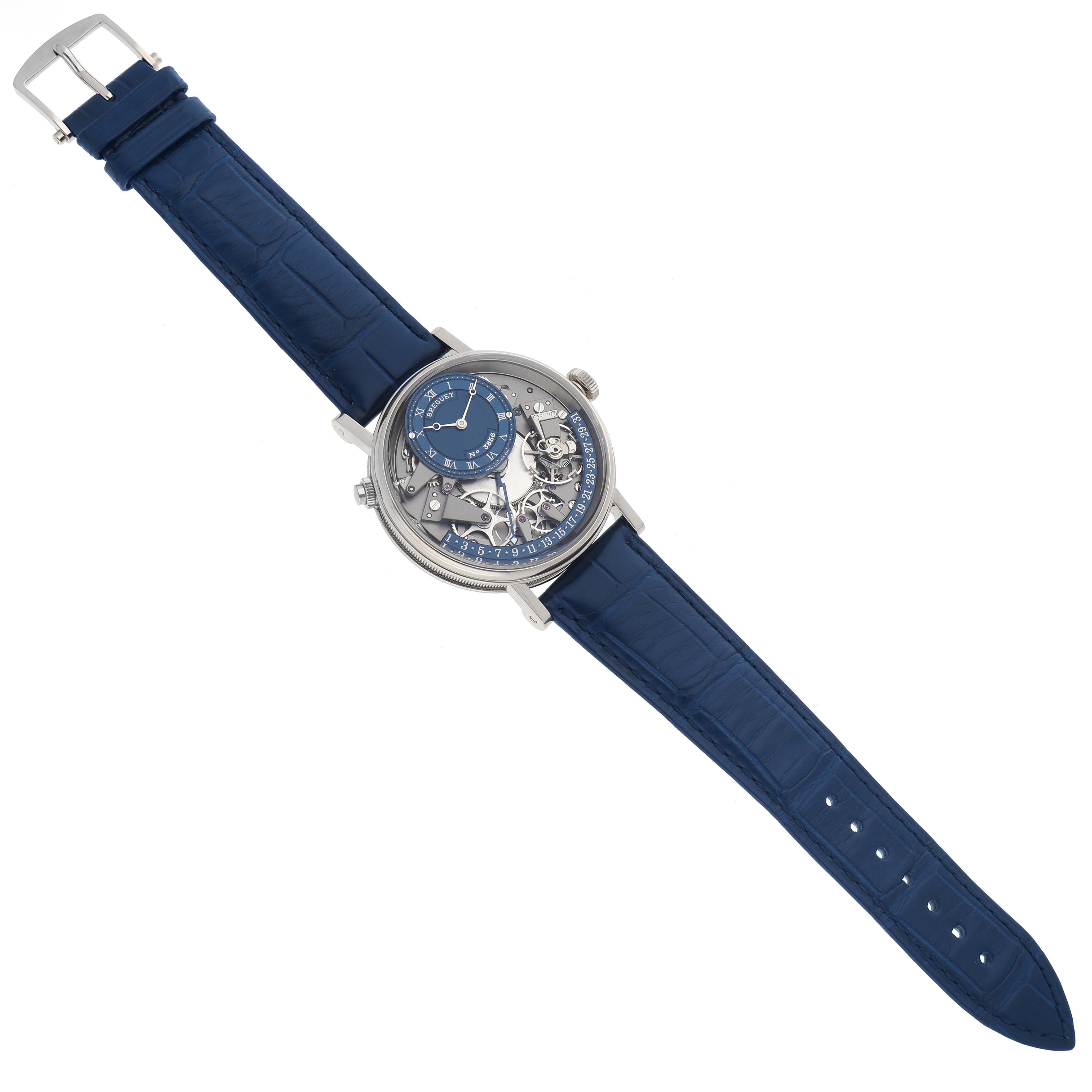 The Breguet Tradition 7597BB/GY/9WU Men's White Gold Blue Dial 7597BB/GY/9WU Men's White Gold Blue Dial watch is shown from a top-down angle, highlighting its blue strap, exposed movement, and intricate dial.