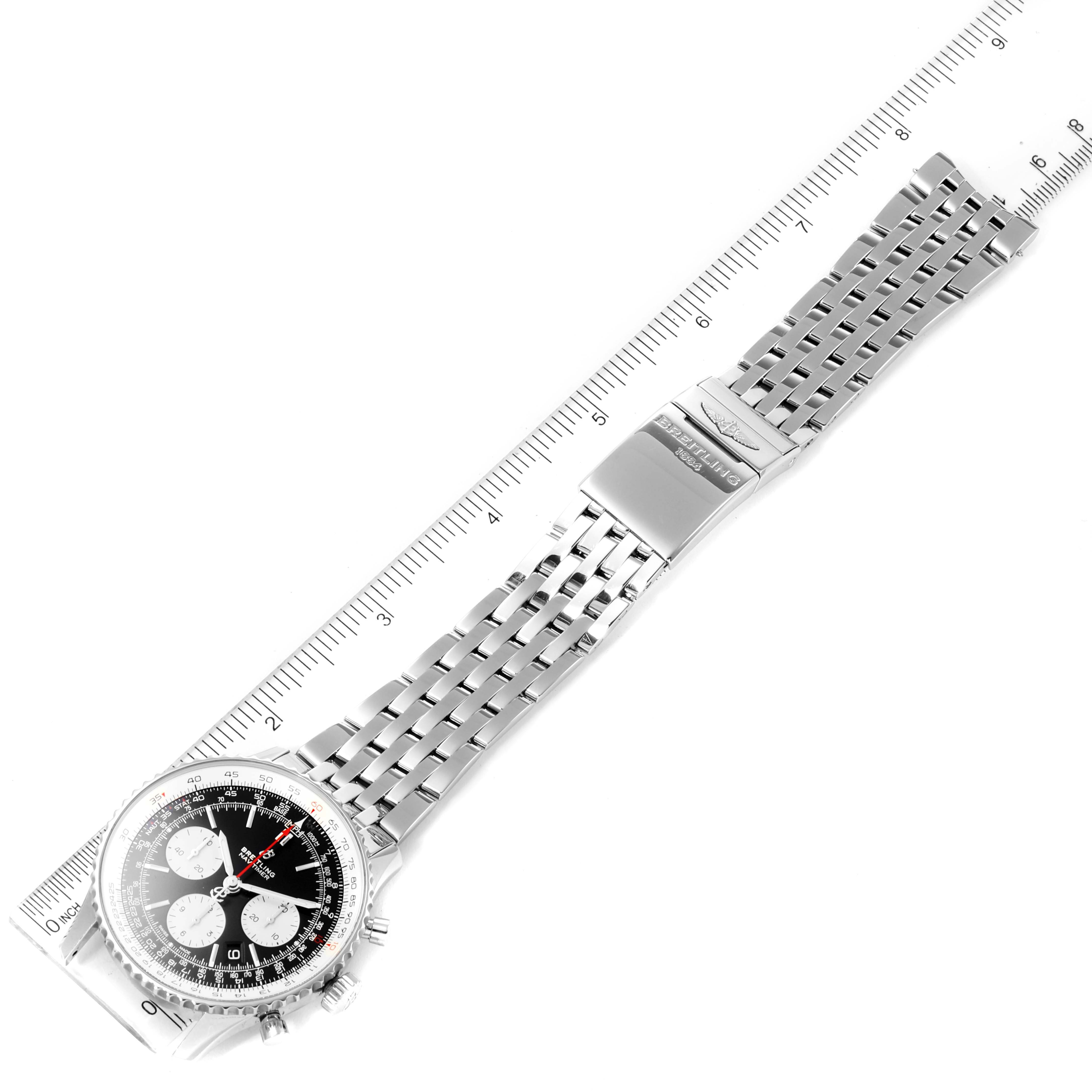 The image shows a top-down view of a Breitling Navitimer AB0121 Men
s Stainless Steel Black Dial AB0121 Men
s Stainless Steel Black Dial watch, featuring its dial, case, and metal bracelet clasp next to a ruler.