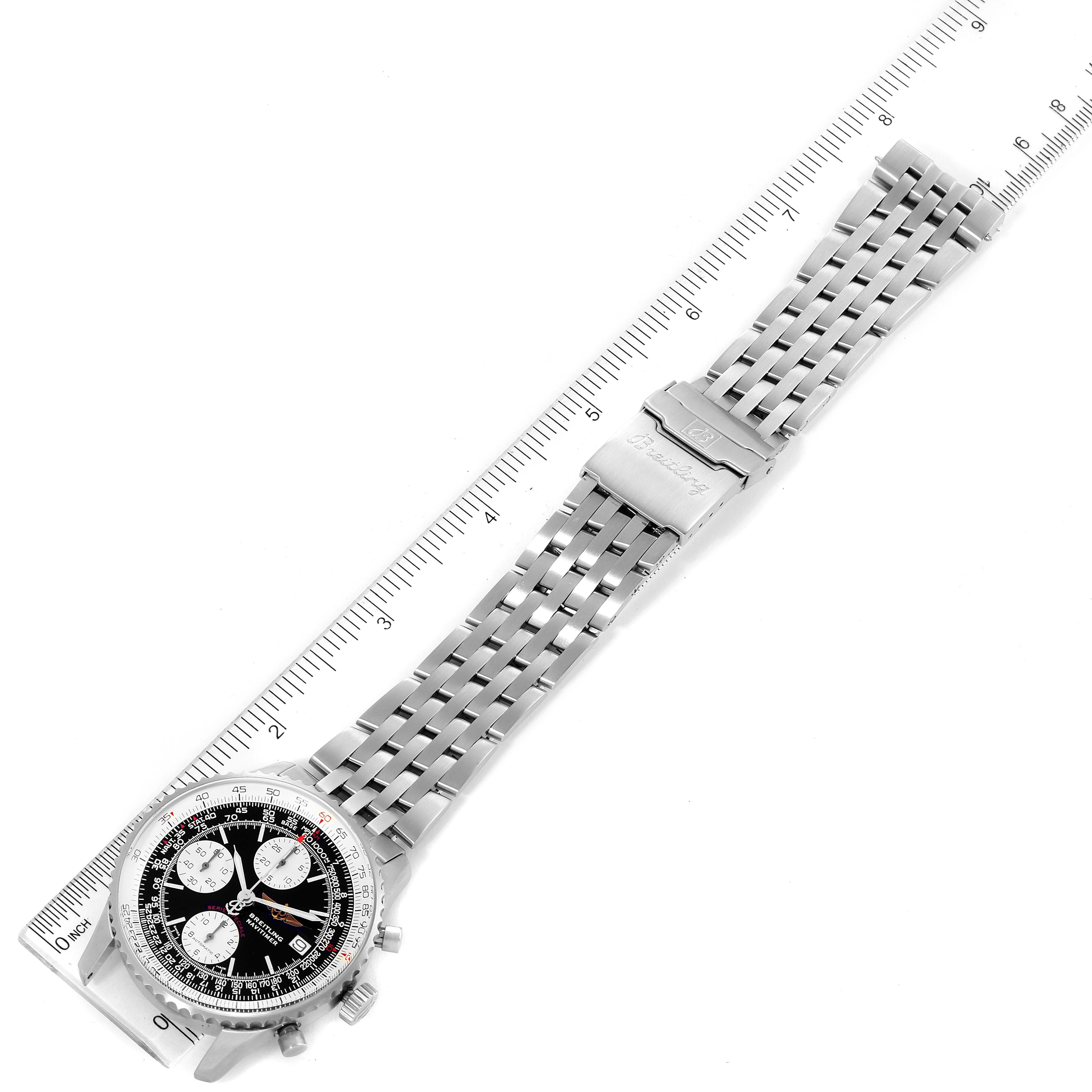 The Breitling Navitimer A13330 Men
s Stainless Steel Black Dial A13330 Men
s Stainless Steel Black Dial watch is shown at an overhead angle, displaying its face, metal bracelet, and clasp alongside a measuring scale.