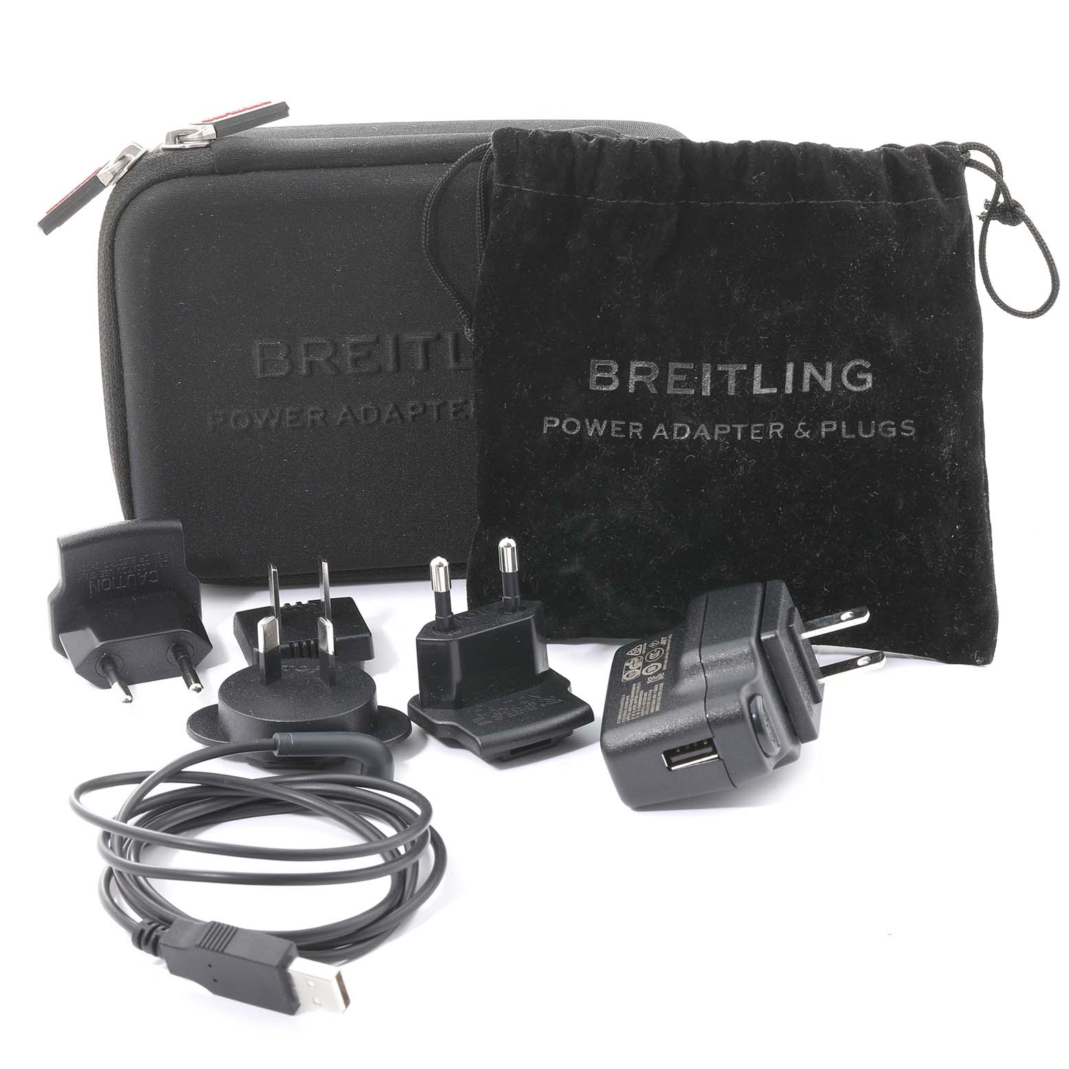 The image shows power adapters, plugs, a USB cable, a zippered case, and a drawstring pouch for the Breitling Professional Series EB5010 Men's Titanium Grey Dial EB5010 Men's Titanium Grey Dial watch.