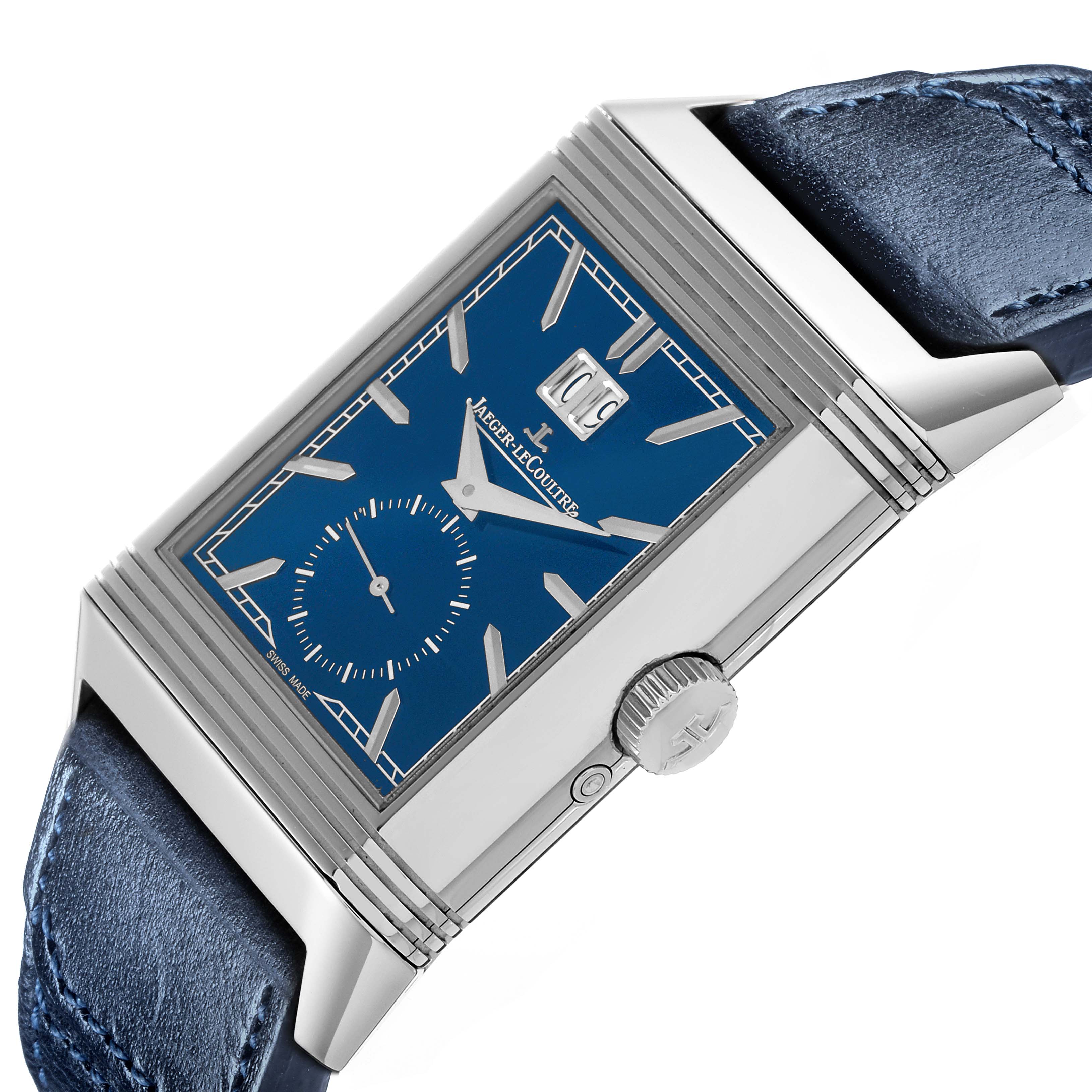 The Jaeger-LeCoultre Reverso watch is shown from a side angle featuring its rectangular case, crown, and part of the blue strap.
