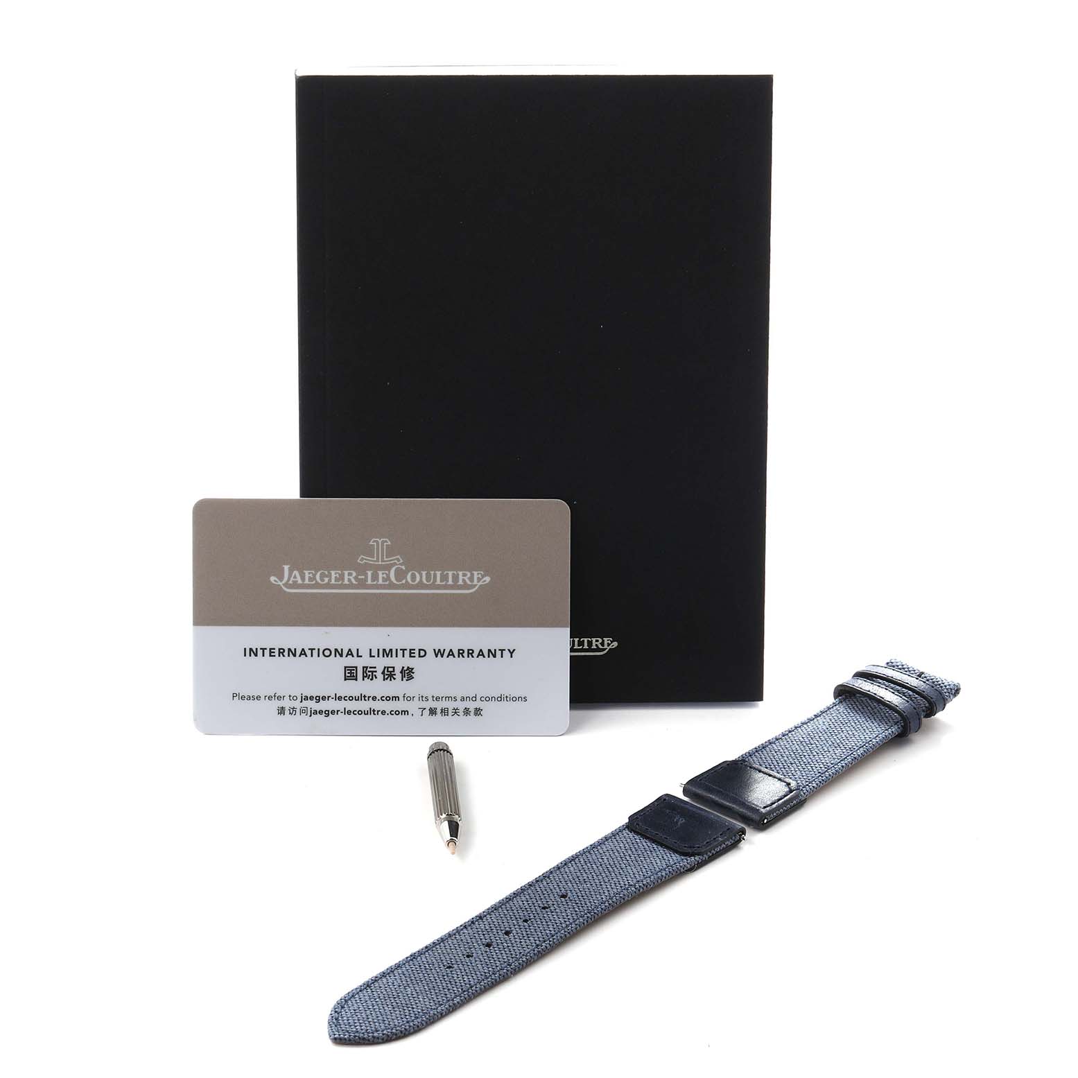 The image shows a Jaeger LeCoultre Reverso Q714845J Men's Stainless Steel Blue Dial Q714845J Men's Stainless Steel Blue Dial watch accessory kit, including a strap, warranty card, booklet, and tool, displayed from above.