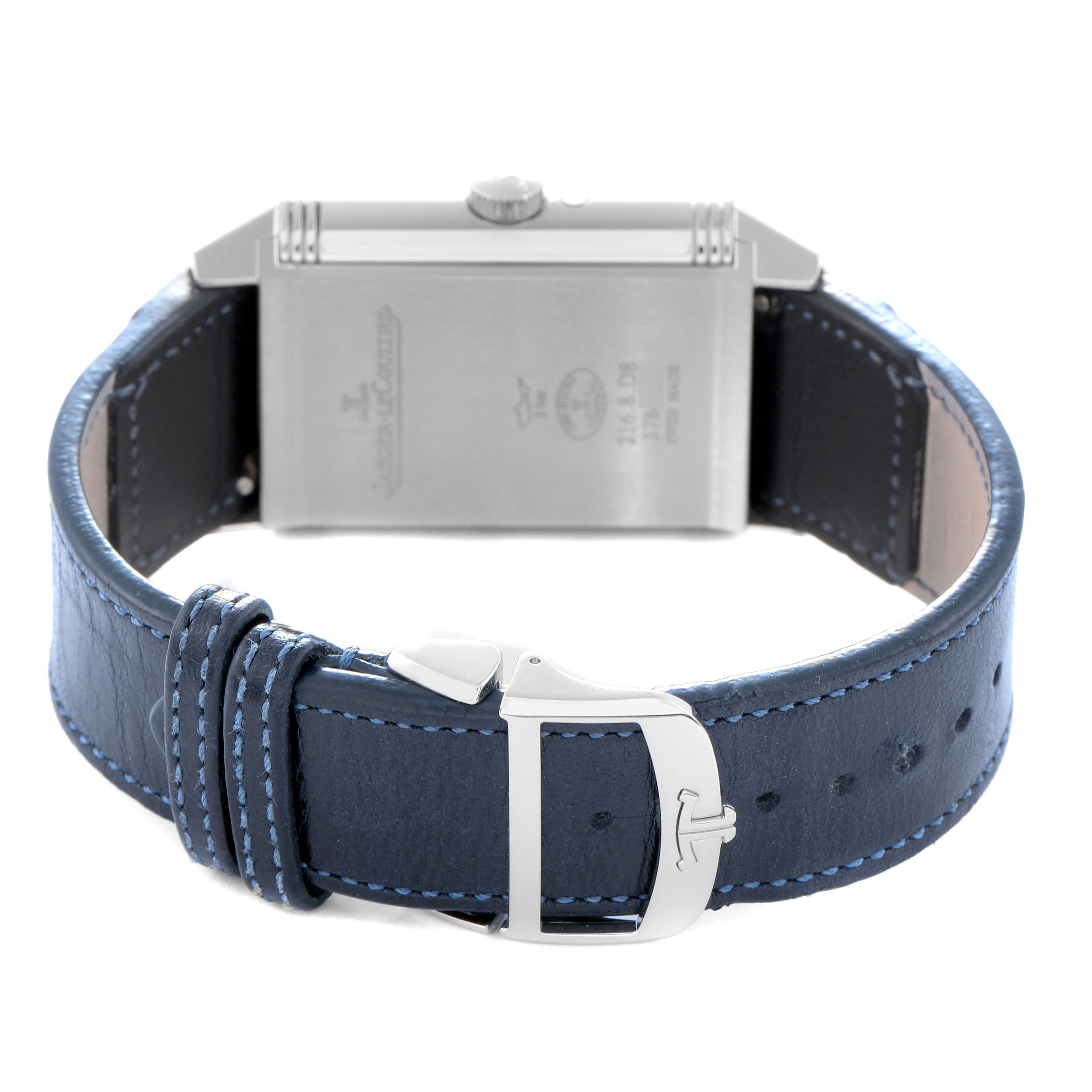 The Jaeger-LeCoultre Reverso watch is shown from the back, focusing on the case and blue leather strap with a buckle.