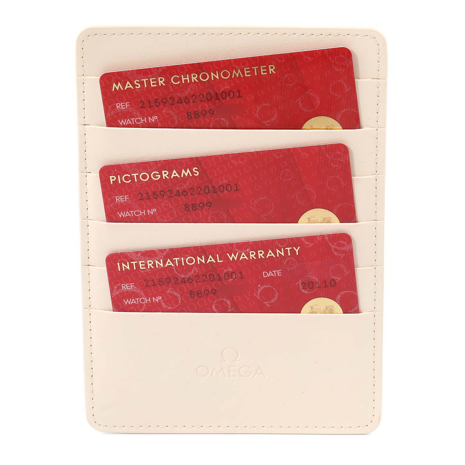 The image shows three warranty cards inside a light-colored Omega holder for the Planet Ocean model watch.