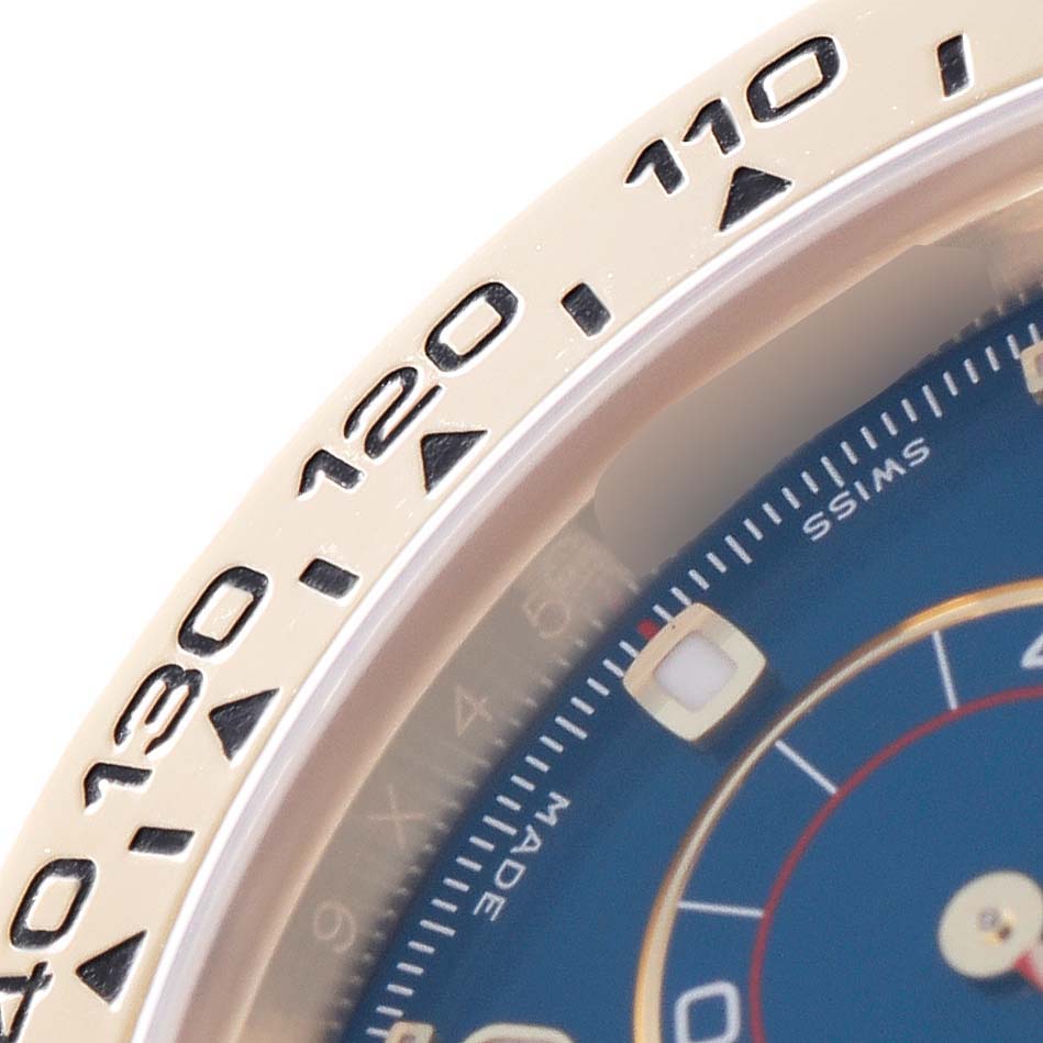 The image shows a close-up of the bezel and partial dial of a Rolex Daytona 116518 Men
s Yellow Gold Blue Dial 116518 Men
s Yellow Gold Blue Dial watch, highlighting the tachymetric scale.