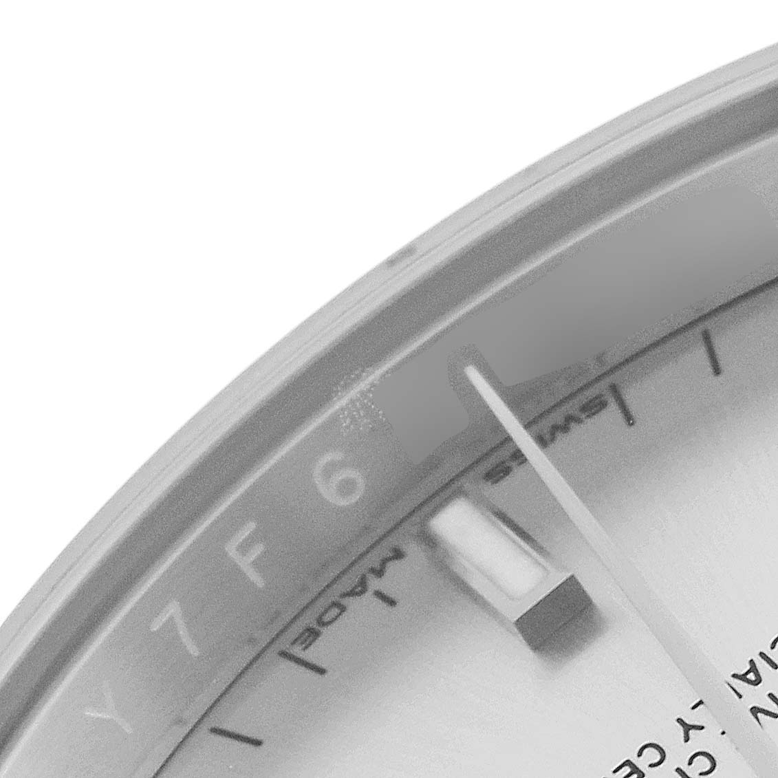 The image shows a close-up of the dial and bezel of a Rolex Date 115200 Men's Stainless Steel Silver Dial 115200 Men's Stainless Steel Silver Dial model watch, focusing on the 6 o'clock position.