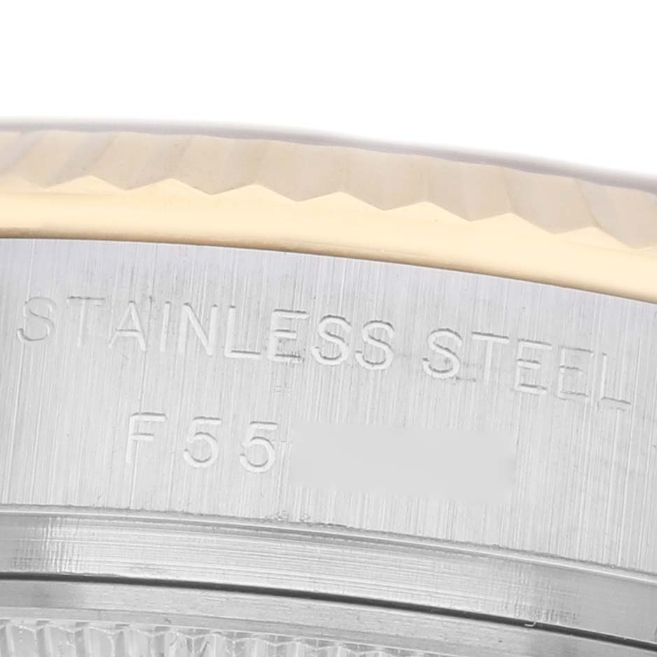 The image shows a close-up of the side of a Rolex Datejust 179173 Women
s Steel and Gold (two tone) Champagne Dial 179173 Women
s Steel and Gold (two tone) Champagne Dial watch, highlighting the stainless steel engraving and part of the bezel.