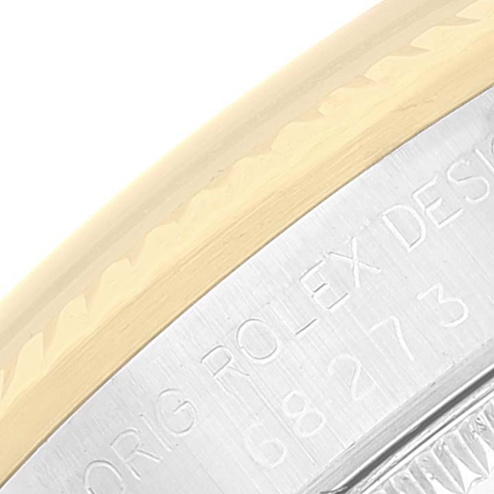 The image shows a close-up of the side bezel and part of the back case with engraved text of a Mid-Size Rolex watch.