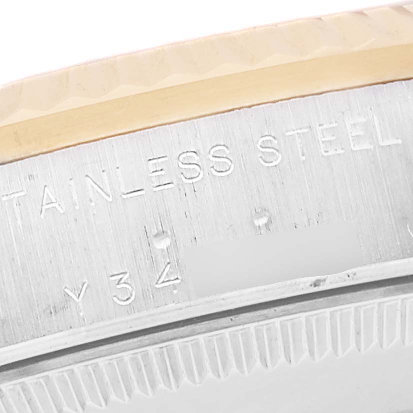 The image shows a close-up angle of the case back and part of the bezel of a Mid-Size Rolex watch, highlighting the stainless steel engraving.