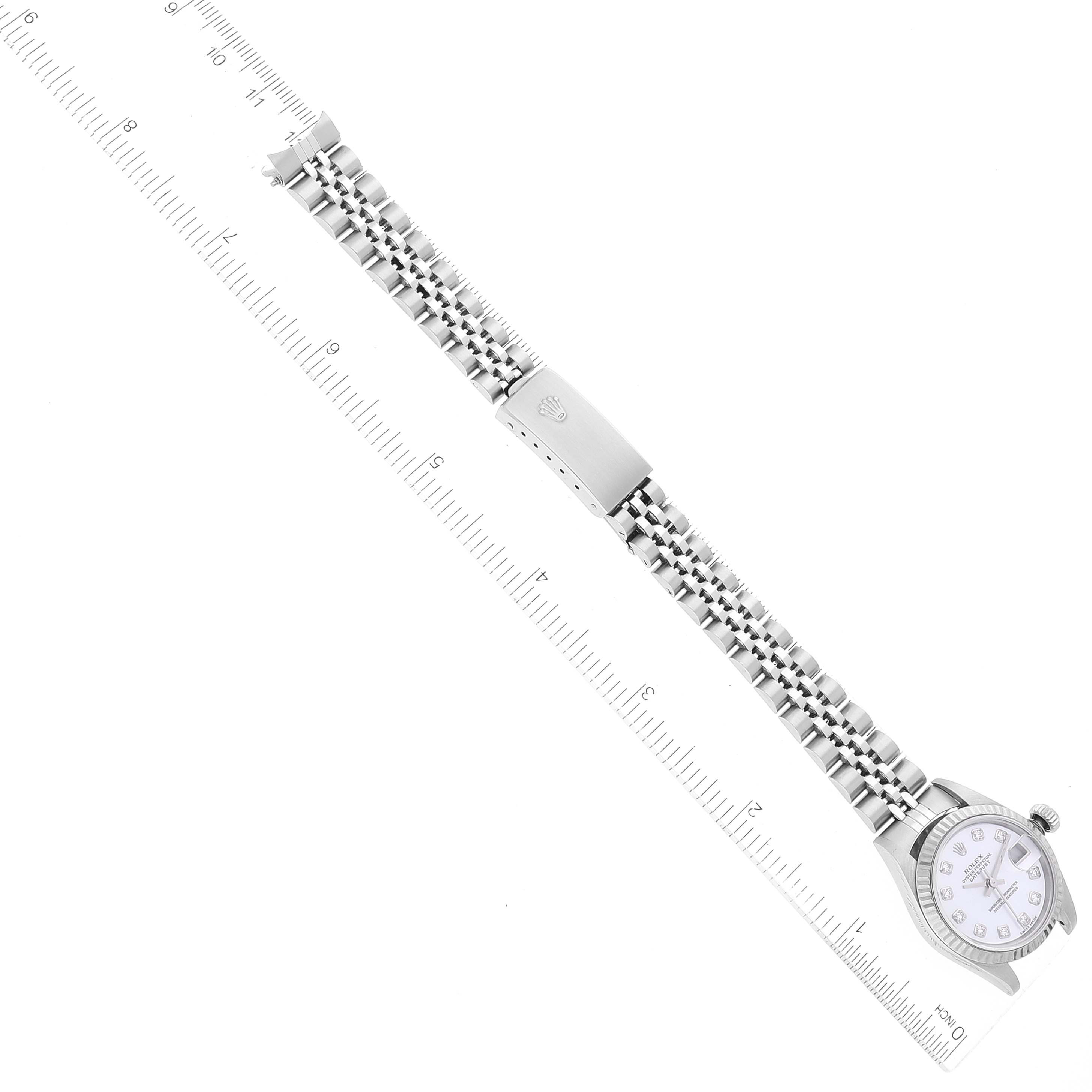 The image shows the full front view of a Rolex Datejust 79174 Women's Stainless Steel Mother of Pearl Dial 79174 Women's Stainless Steel Mother of Pearl Dial watch, including its bracelet and clasp, alongside a measuring ruler for scale.