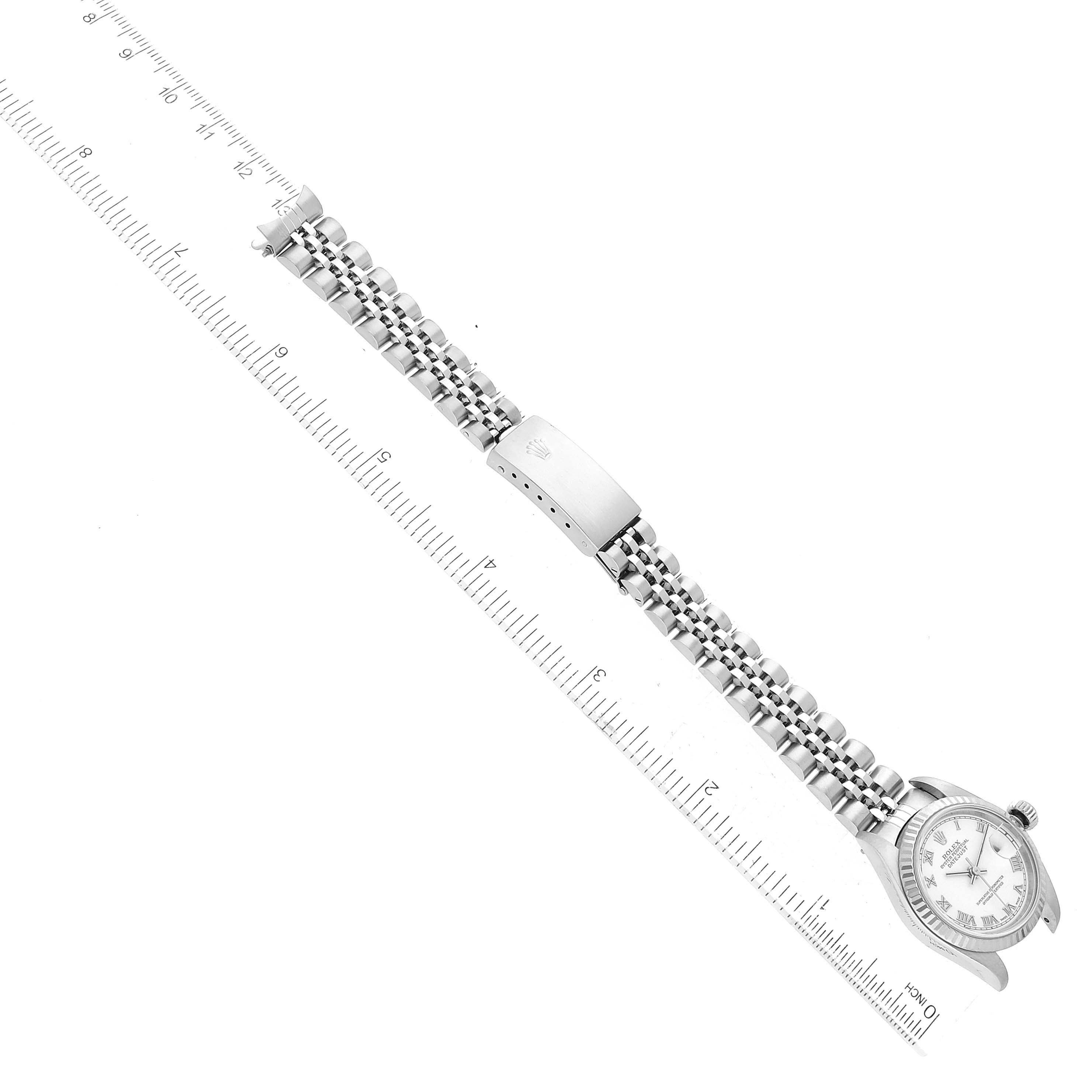 The image shows a Rolex Datejust 79174 Women's Stainless Steel White Dial 79174 Women's Stainless Steel White Dial watch laid flat with its bracelet and clasp fully visible, alongside a ruler for scale.