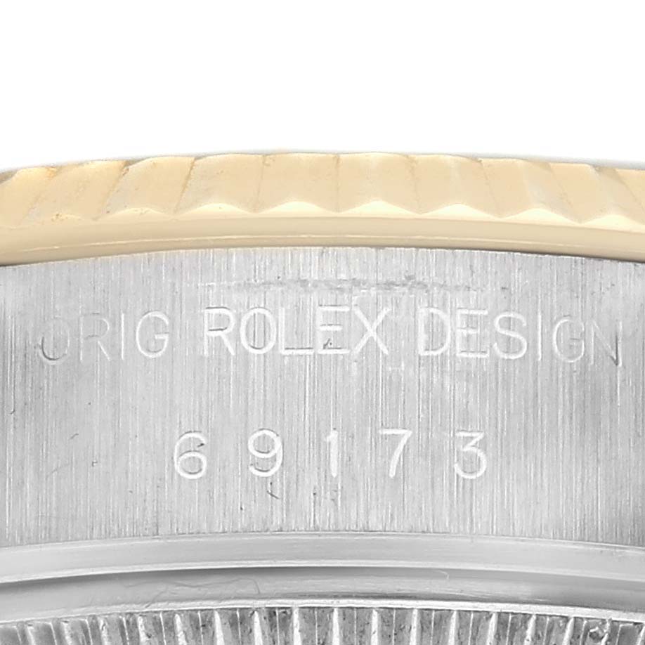 The image shows a close-up of the case side of a Rolex Datejust 69173 Women
s Steel and Gold (two tone) Black Dial 69173 Women
s Steel and Gold (two tone) Black Dial, highlighting the model number and "ROLEX DESIGN" engraving.